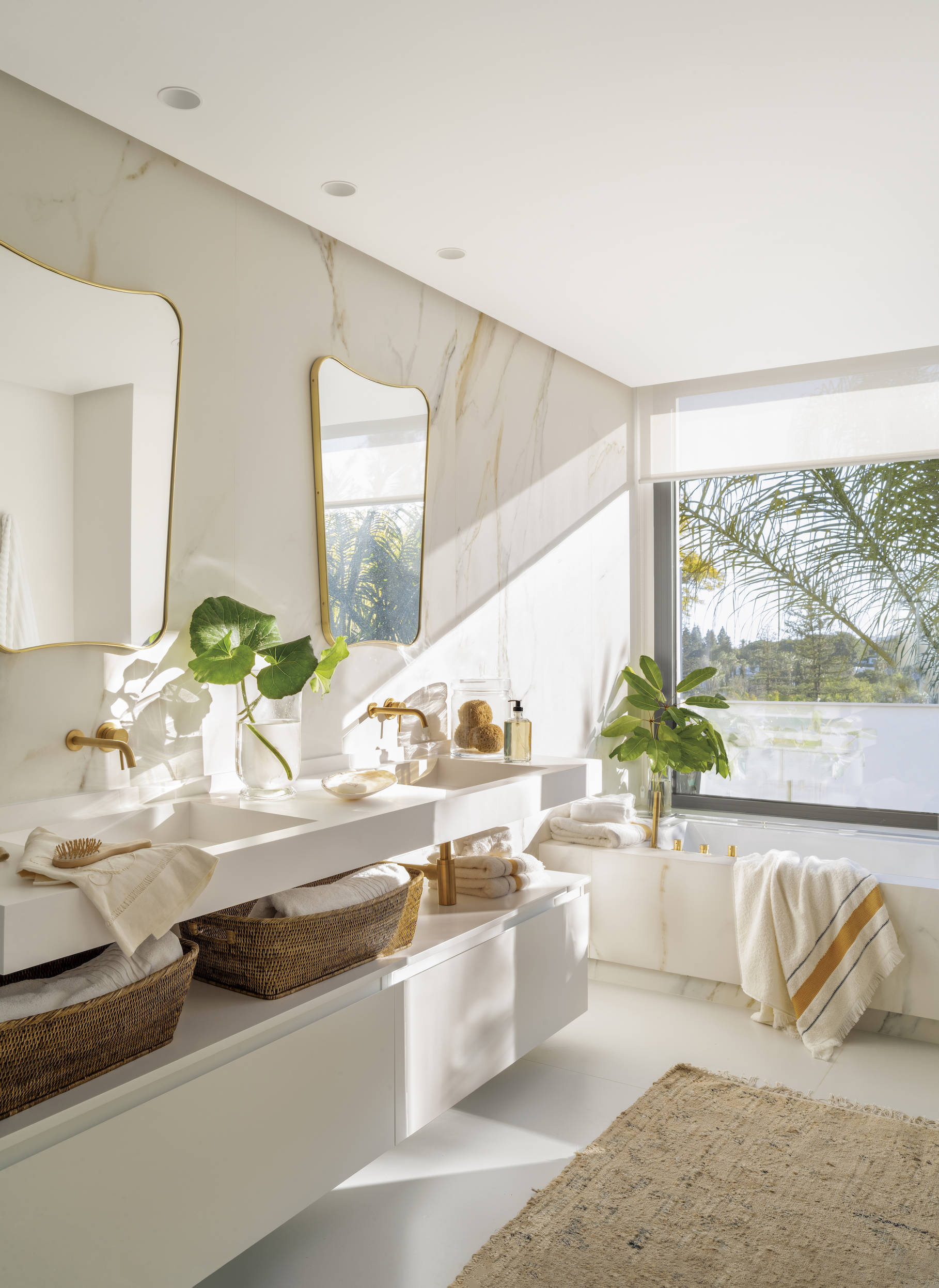 Baño moderno con mueble blanco y paredes de ma´rmol