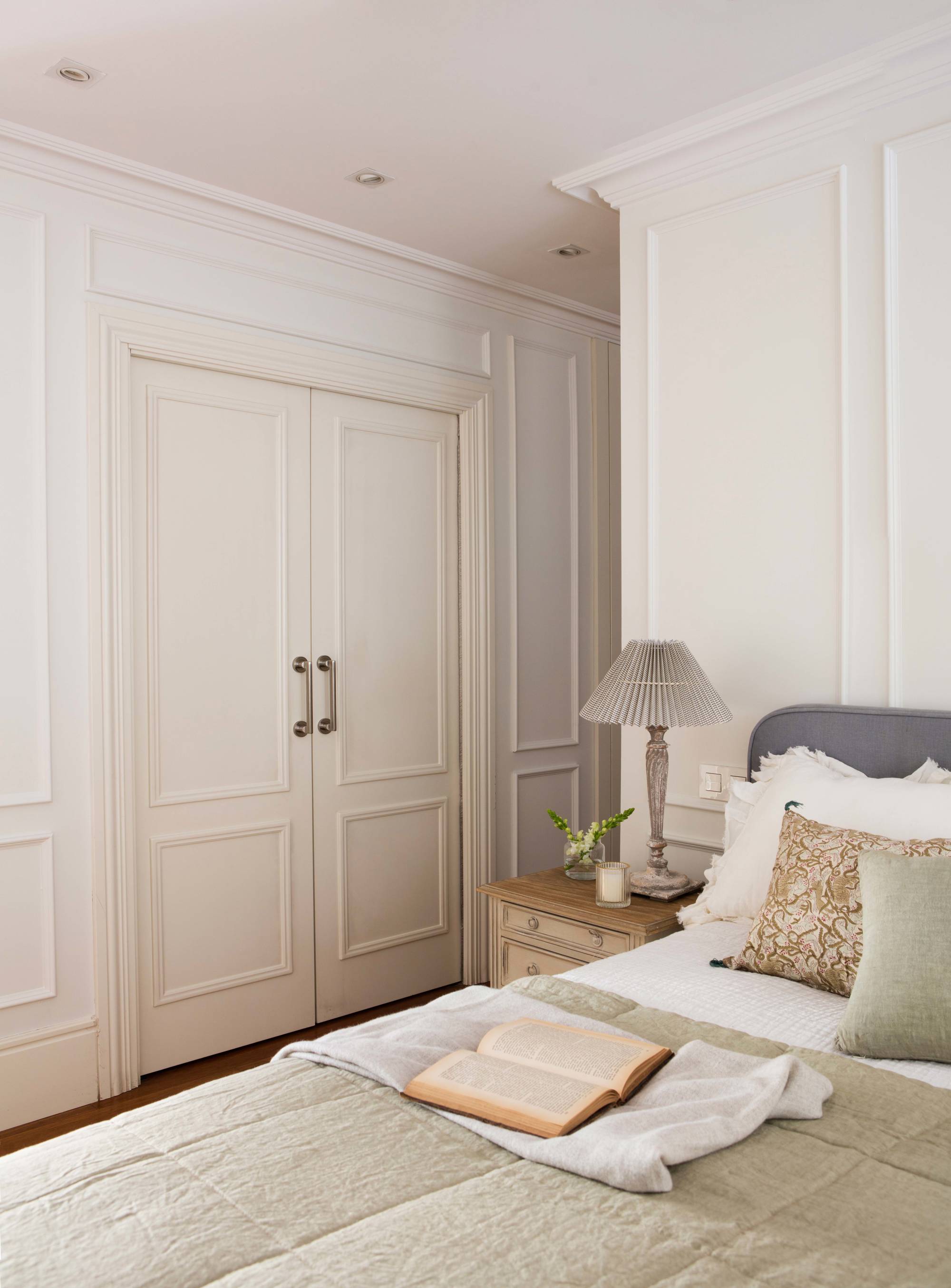 Dormitorio con molduras decorativas y puertas correderas