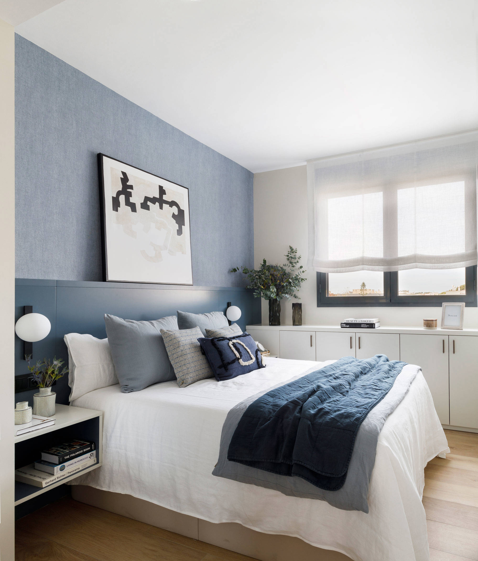 Dormitorio en blanco y azul con mobiliario a medida diseñado por Pia Capdevila.