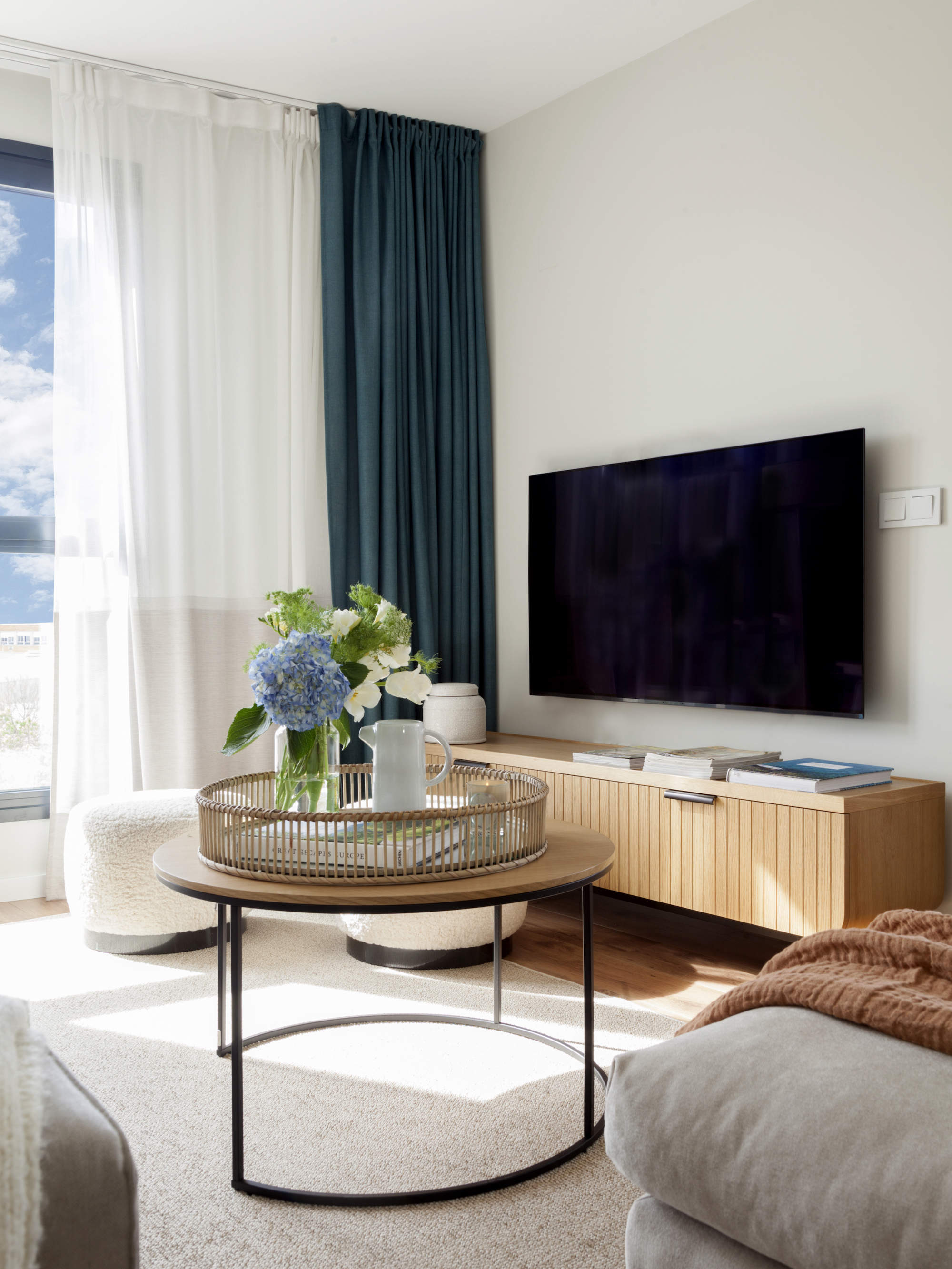 Salo´n con mueble de TV de madera, mesita de madera y hierro y alfombra blanca Majo Flores
