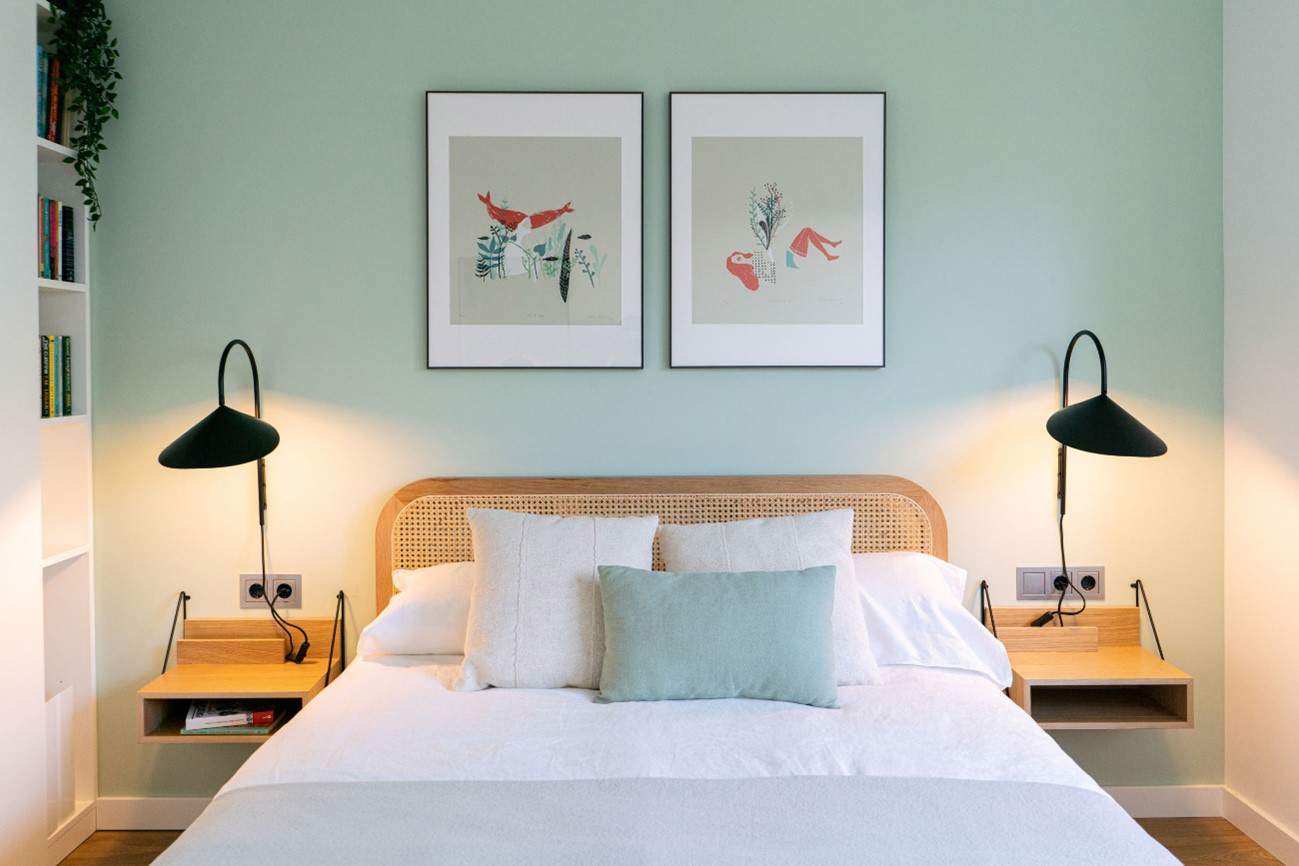 Dormitorio con pared de cabecero pintado de verde, proyecto de Coblonal Interiorisme.