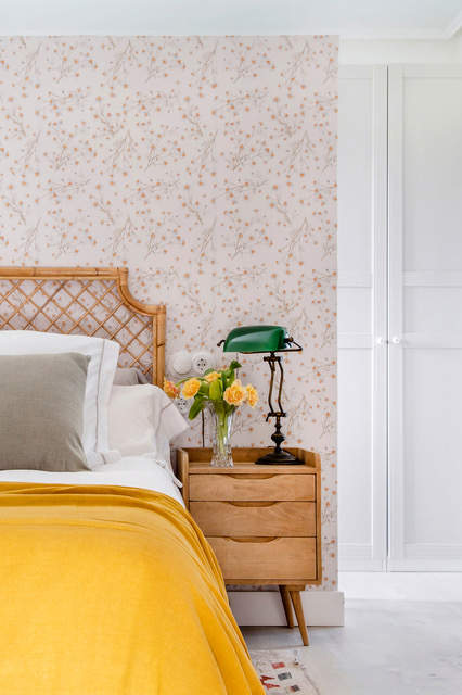 Dormitorio decorado en mostaza con papel pintado floral.