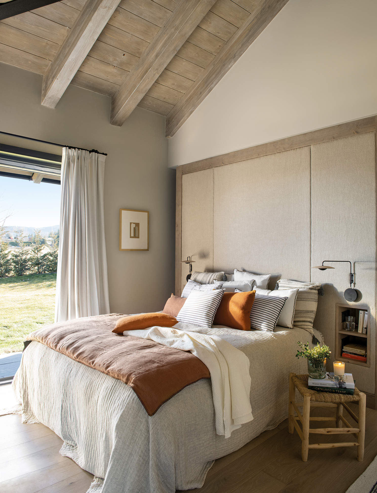 Dormitorio con cabecero tapizado de pared a pared.