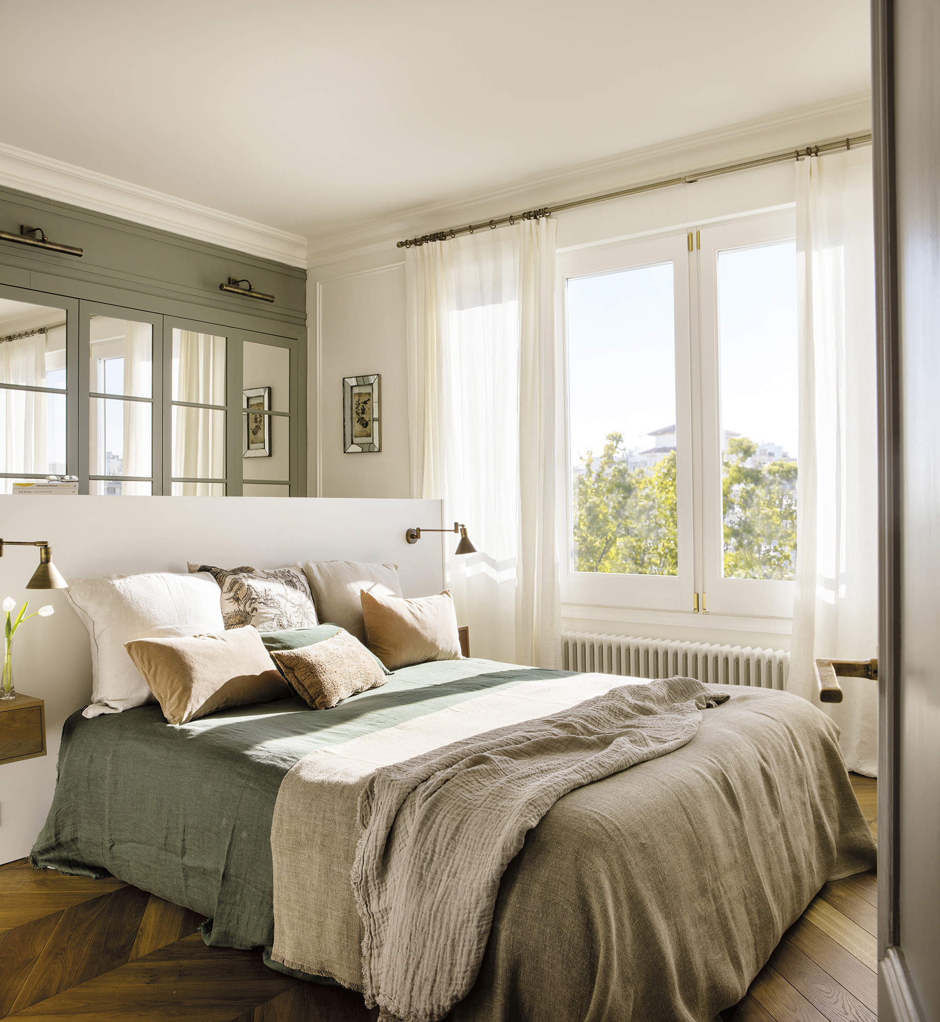 Dormitorio con suelos de madera y ropa de cama ligera