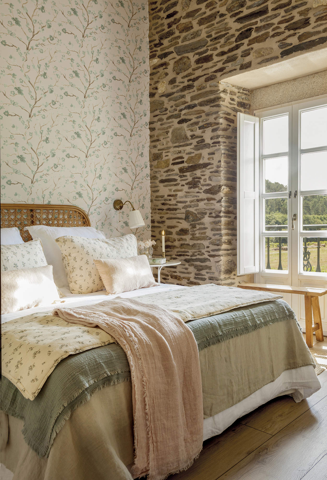 Dormitorio rústico con pared de piedra y papel pintado.