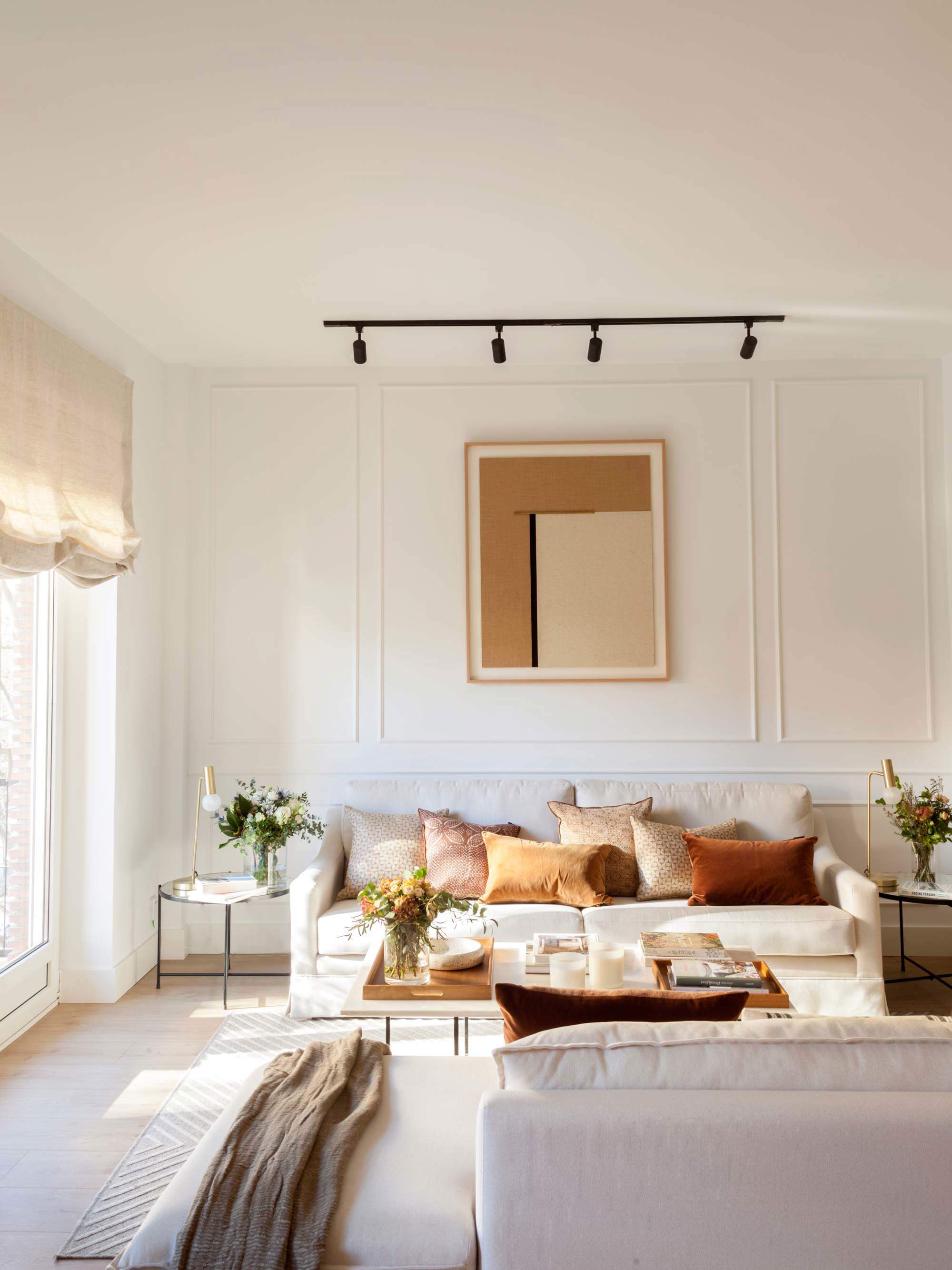 Salón con sofás tapizados en tonos neutros y cuadro en la pared.