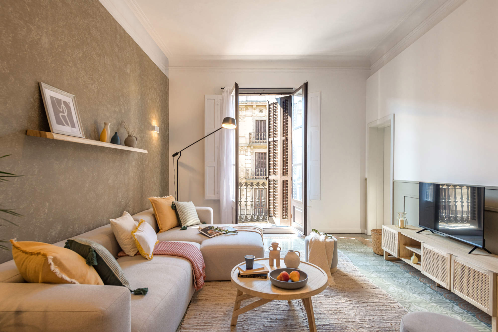 Salón pequeño con sofá con chaise longue, arrimadero, papel pintado y acceso a la terraza.