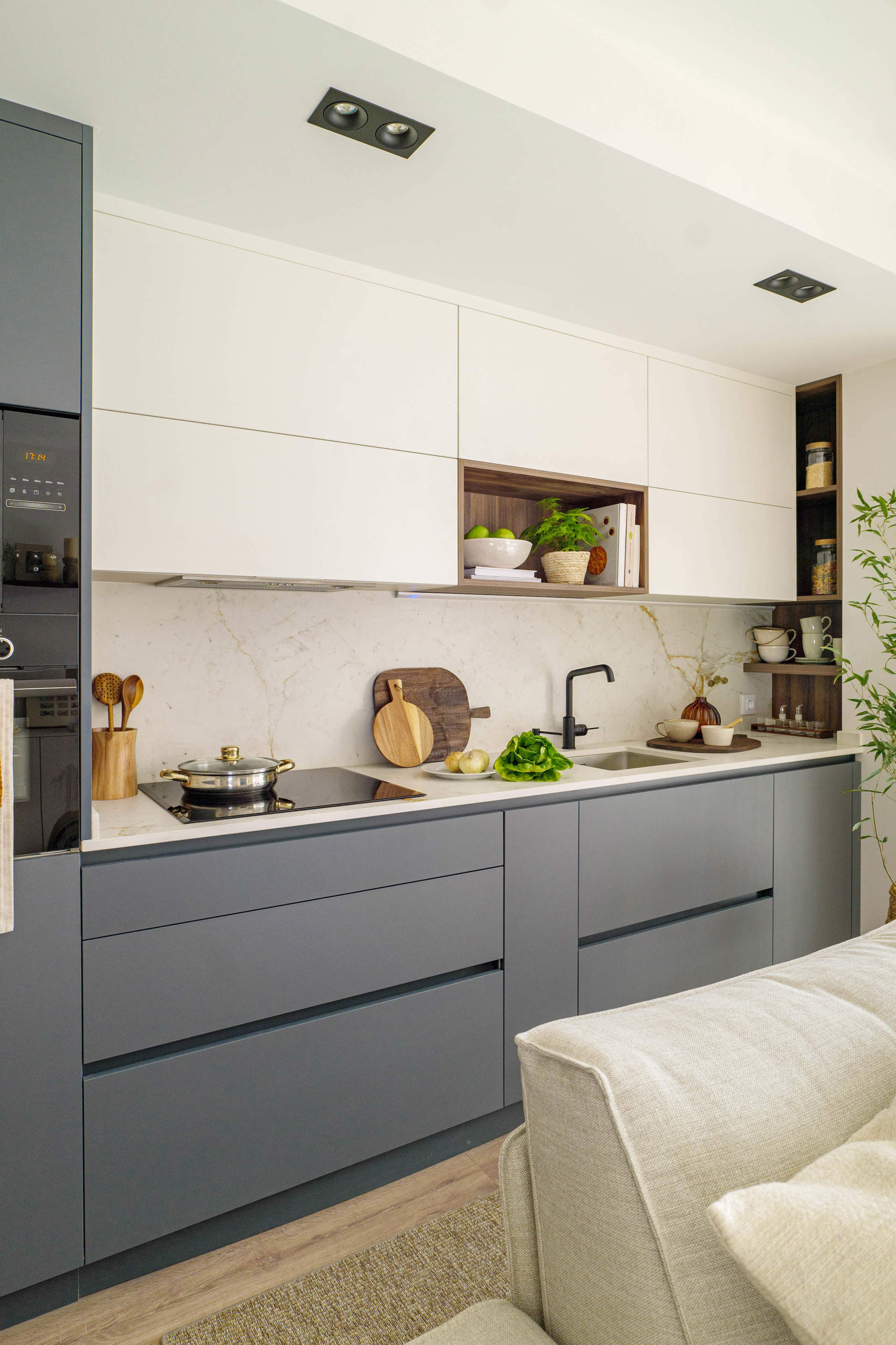 Cocina abierta blanca y gris con suelo de madera y antepecho de marmol por quefalamaria