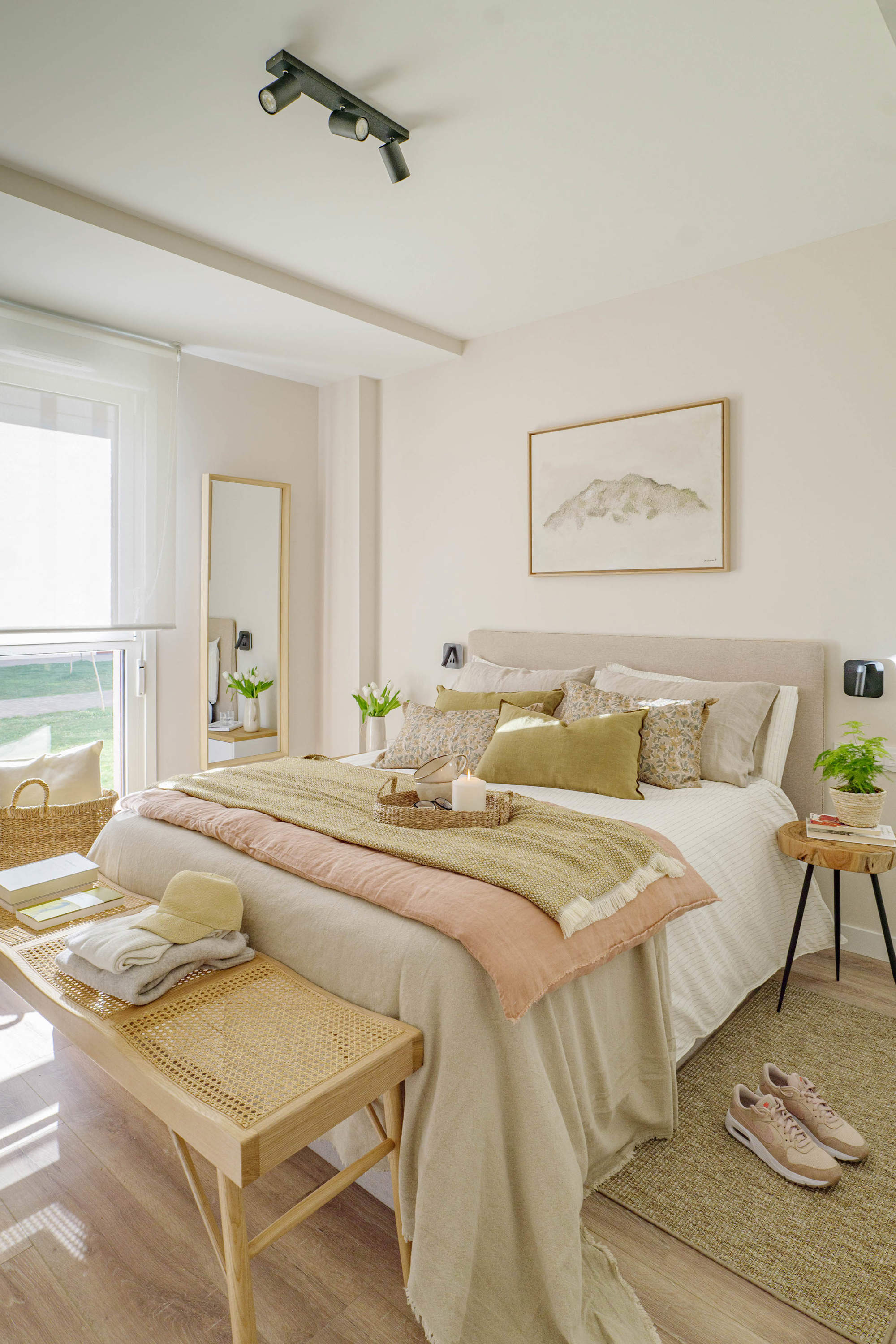 Dormitorio con cabecero de lino, banqueta de madera y textiles mostaza por quefalamaria