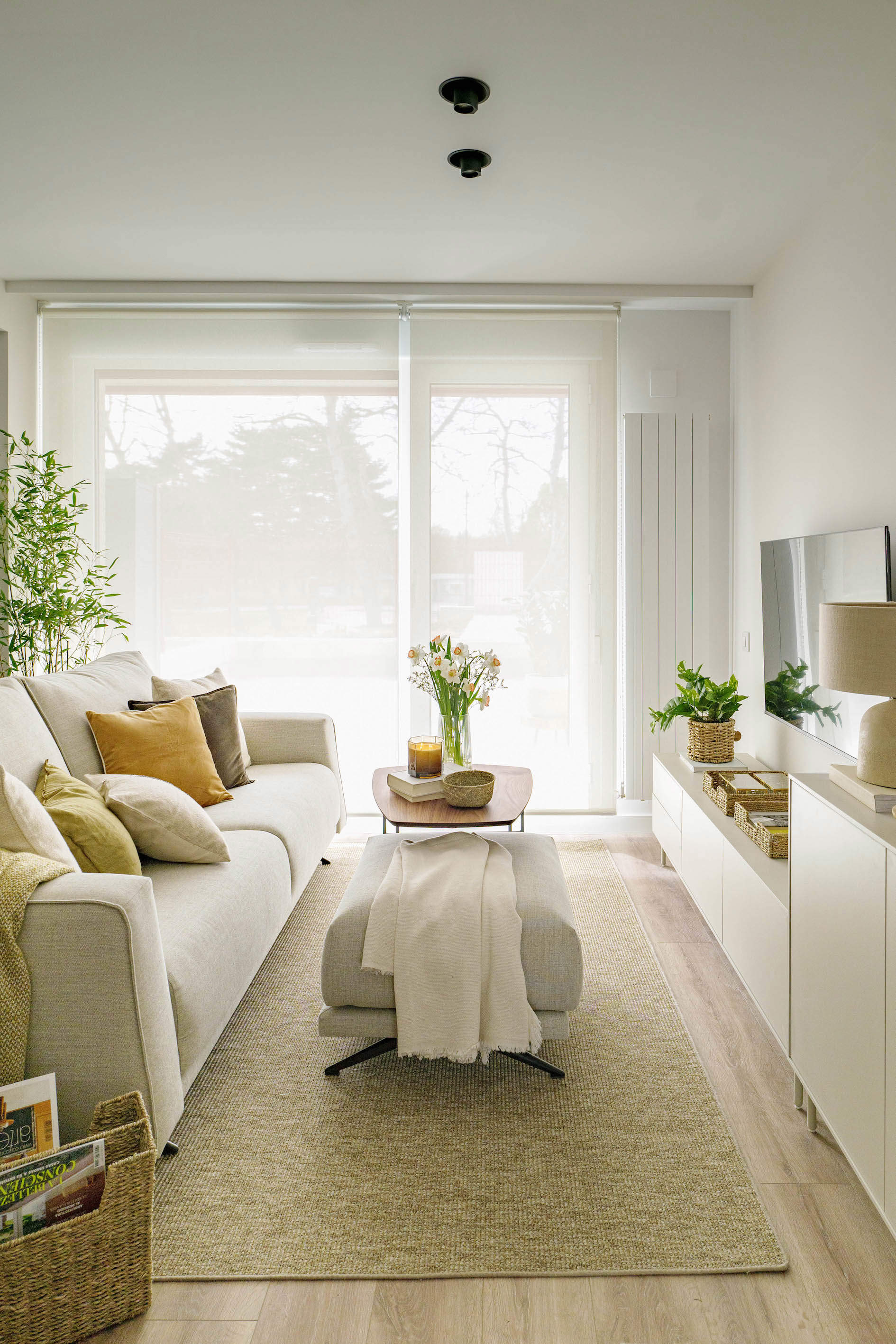 Salo´n blanco con sofa´ beige, alfombra de fibras y mueble modular por quefalamaria