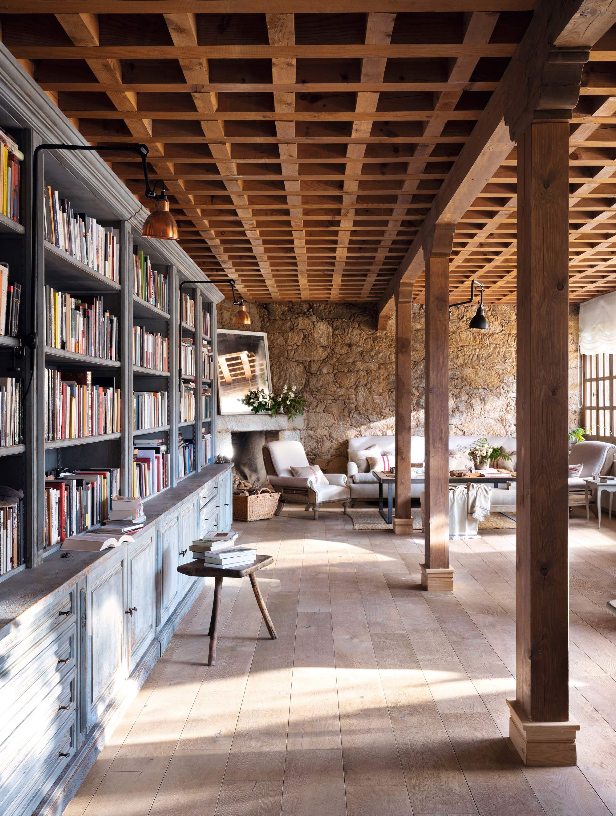 Salón con techo artesonado, suelo de madera natural y librería extra larga.