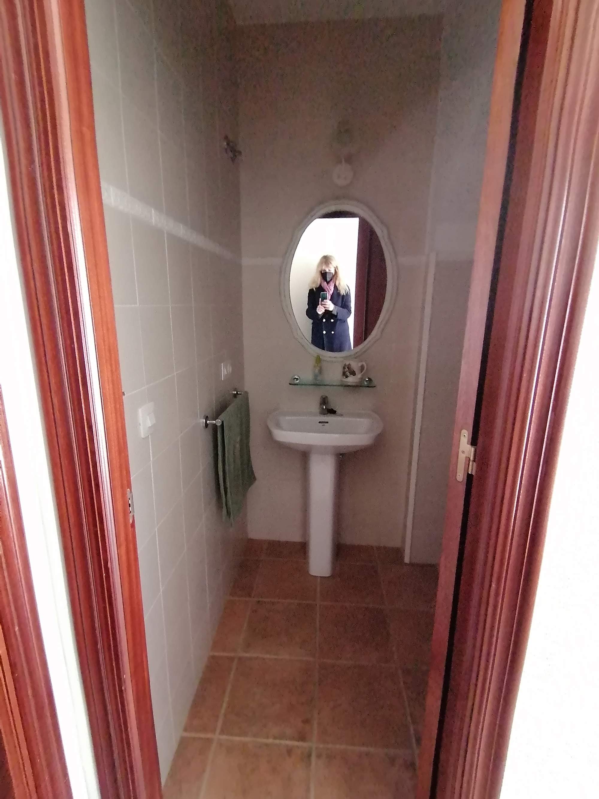 Un primer aseo con el lavabo, un toallero y un espejo.
