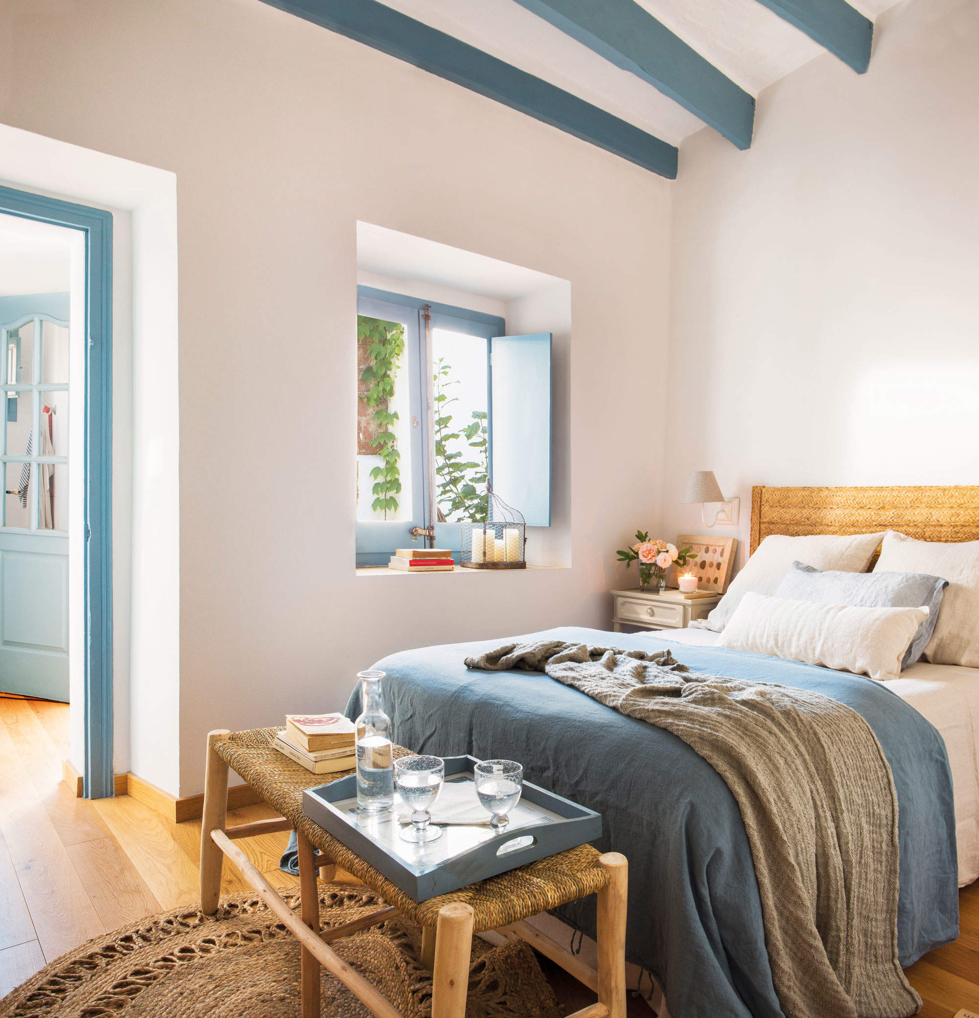 Decoración de verano dormitorio con vigas y porticones en azul.