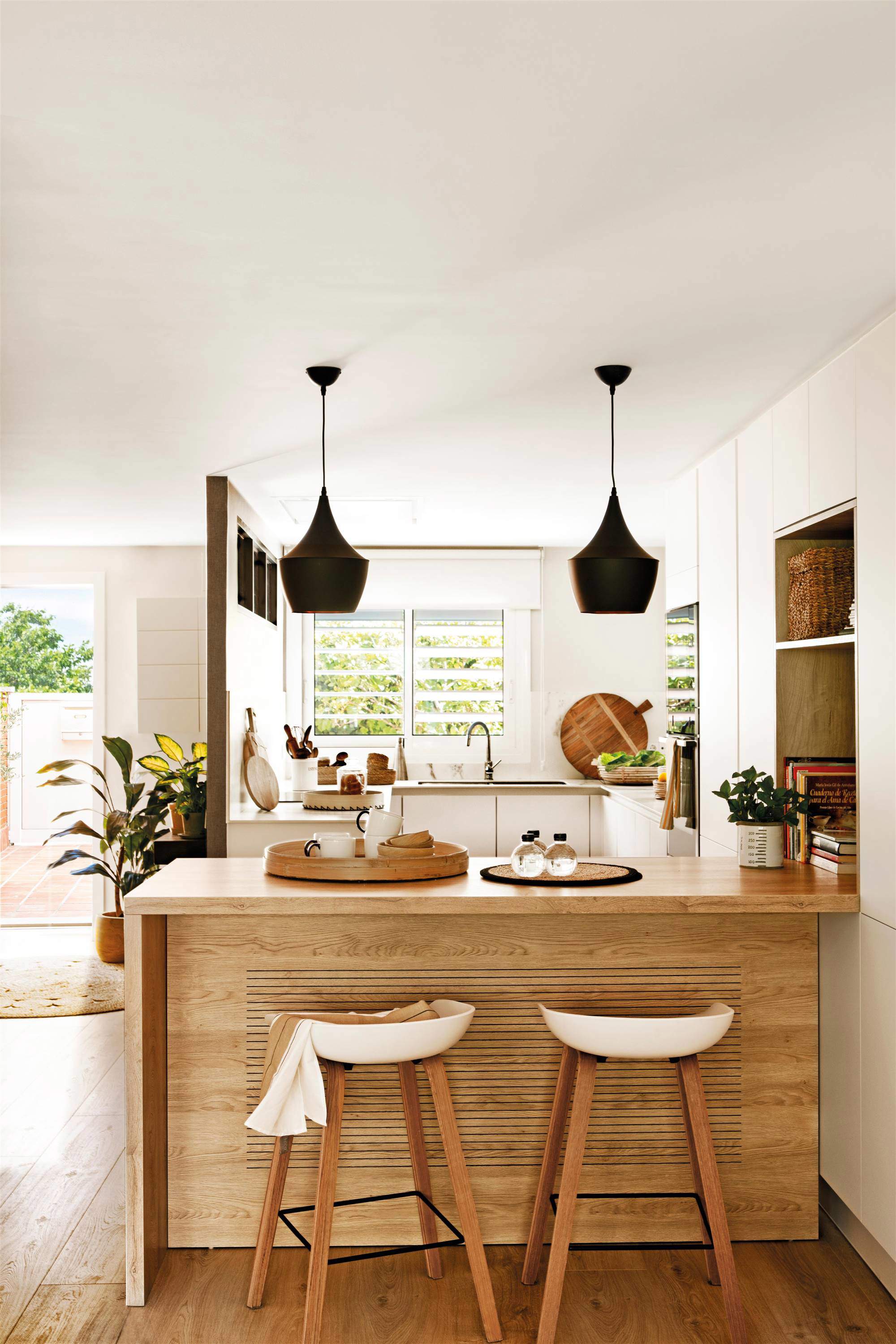 Una cocina blanca con península de madera.