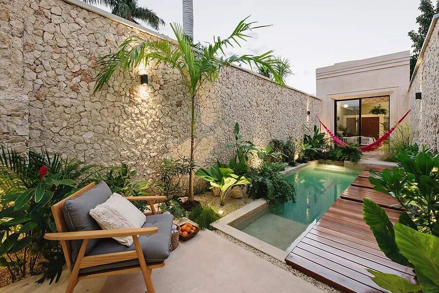 Patio central con piscina, butaca y plantas de exterior. 