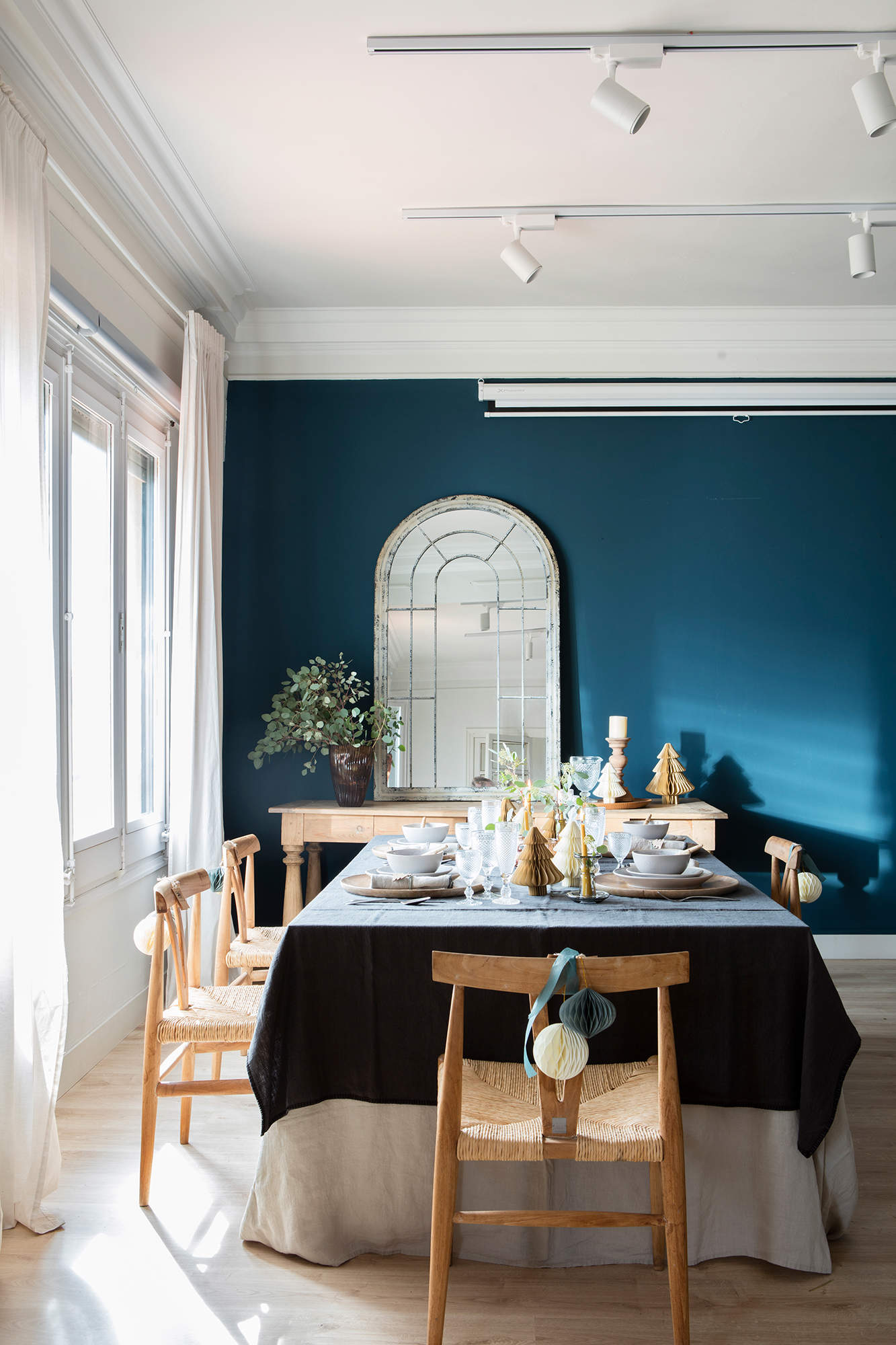Comedor con pared pintada en azul y decoración navideña.