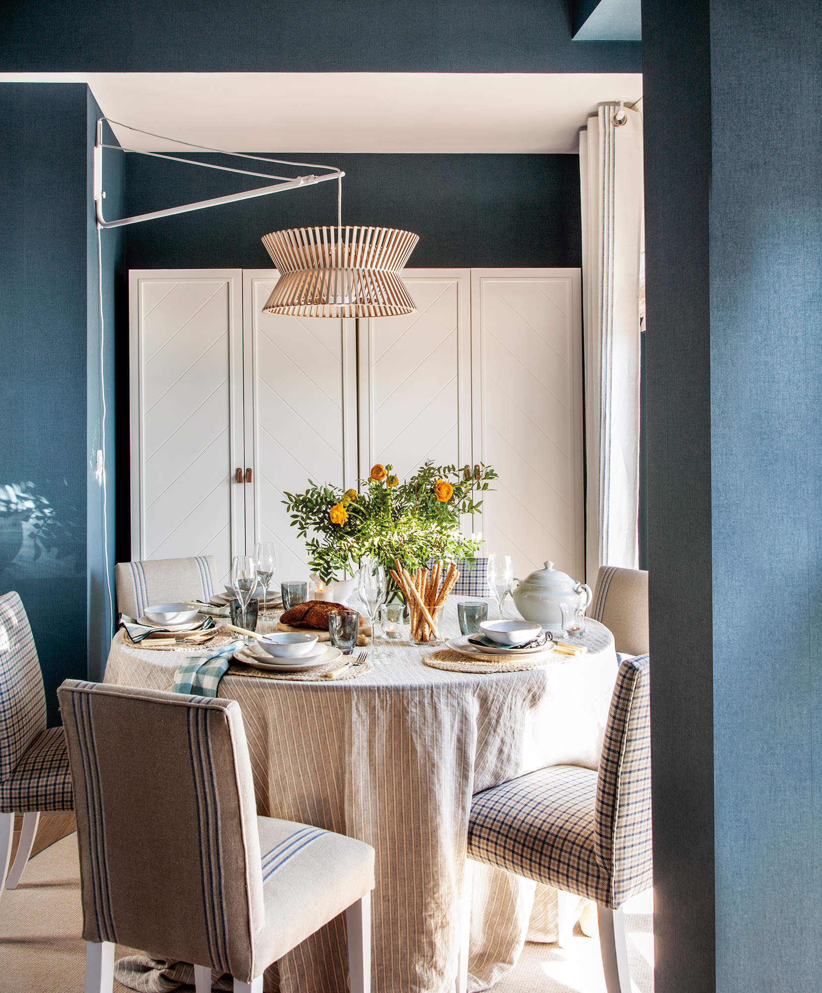 Comedor con paredes en azul y mesa de comedor redonda.