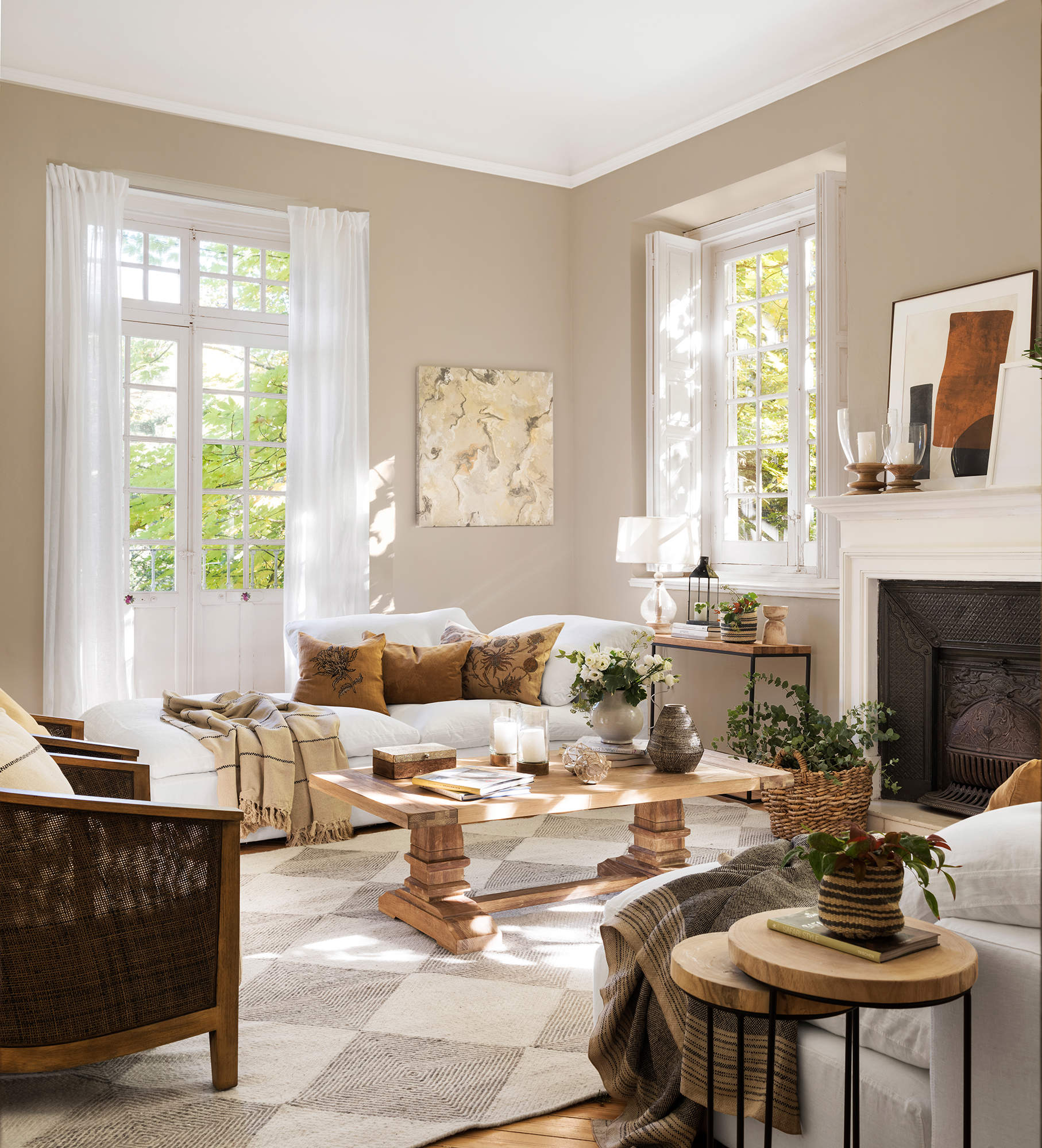 Salón decorado en tonos neutros con chaise longue, alfombra a cuadros y chimenea. 