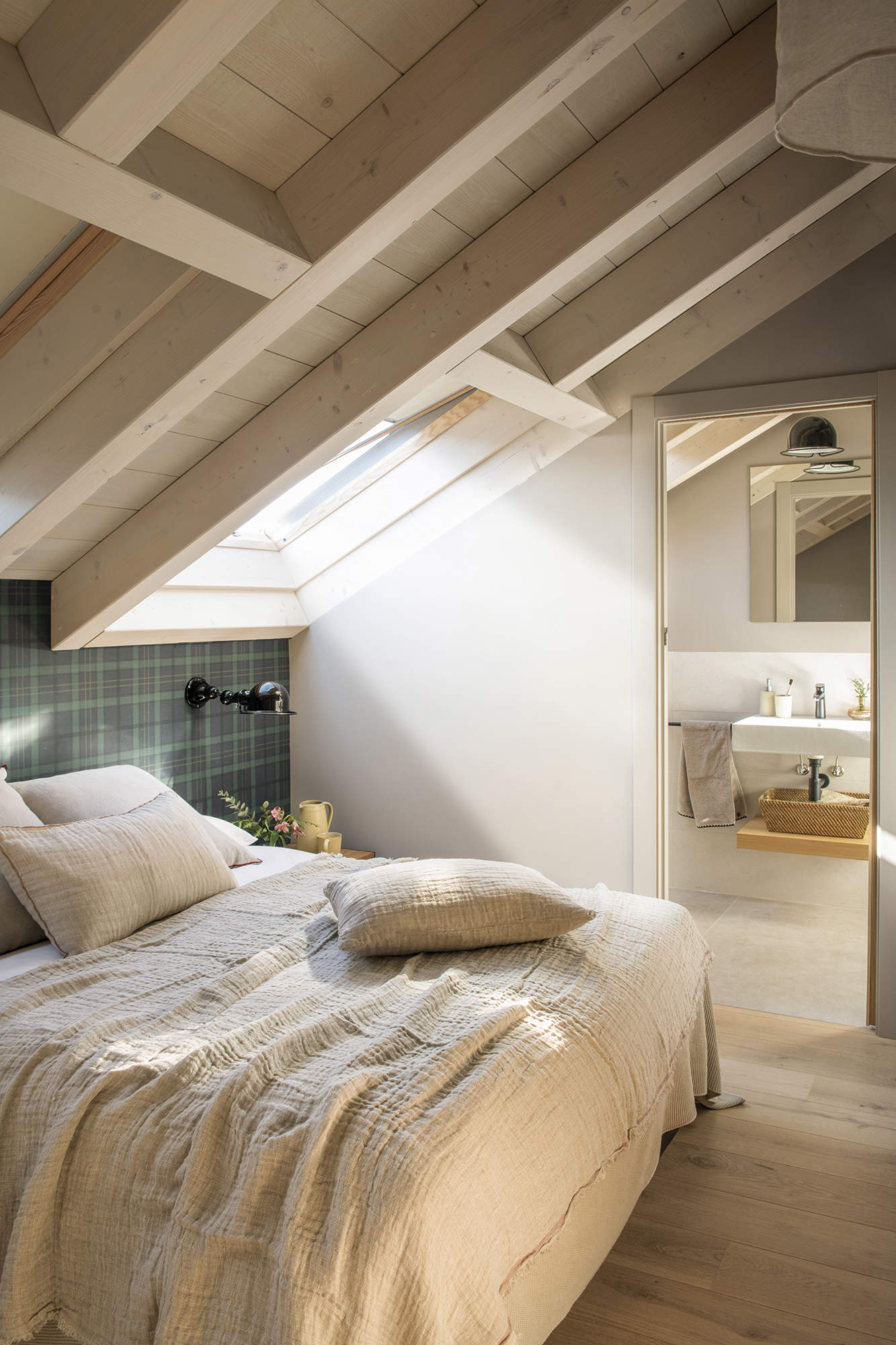 dormitorio con baño, empapelado a cuadros, suelo de madera, techo abuhadrillado