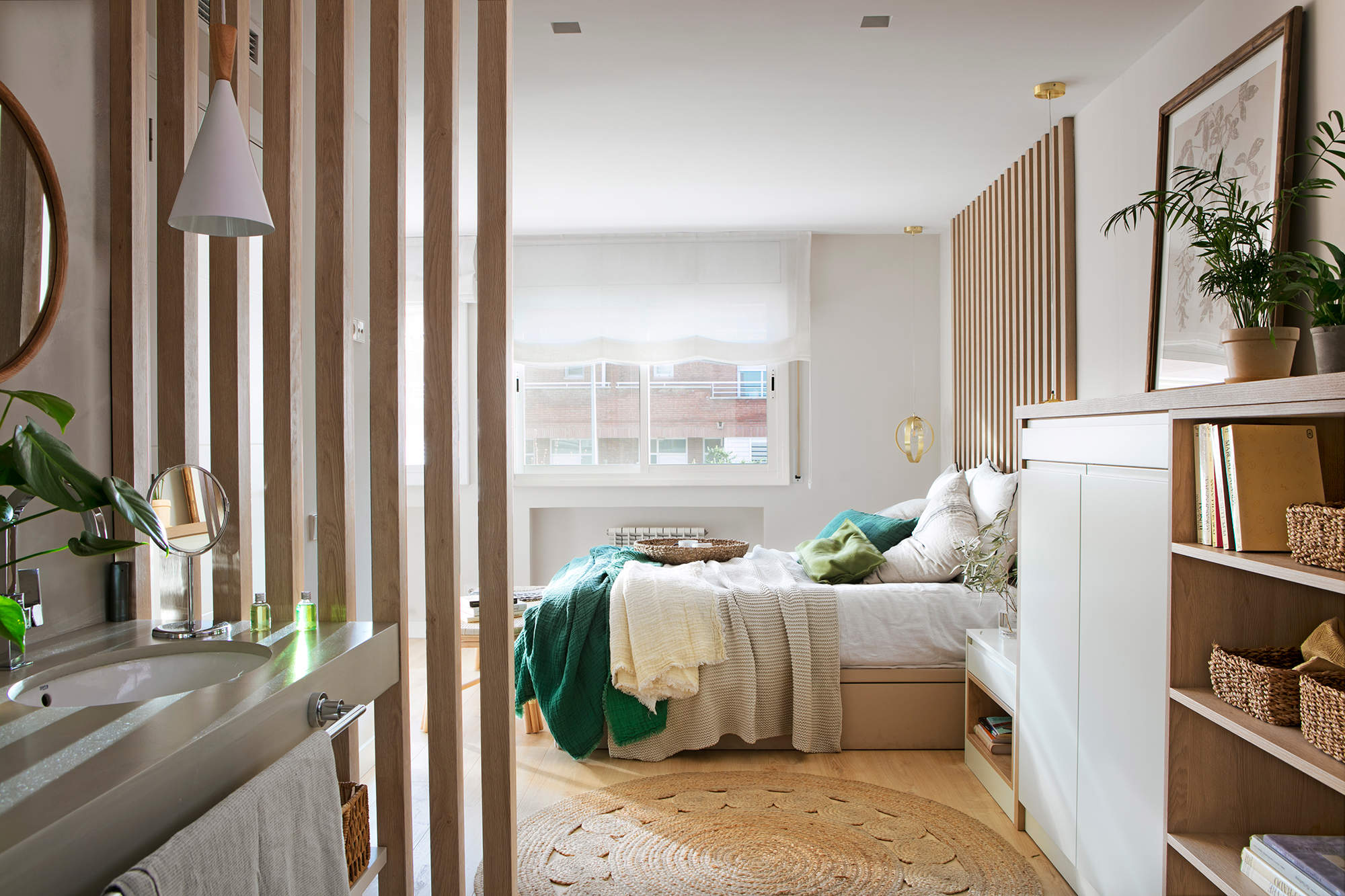 Dormitorio con panel decorativo de listones de madera como separación en el baño.