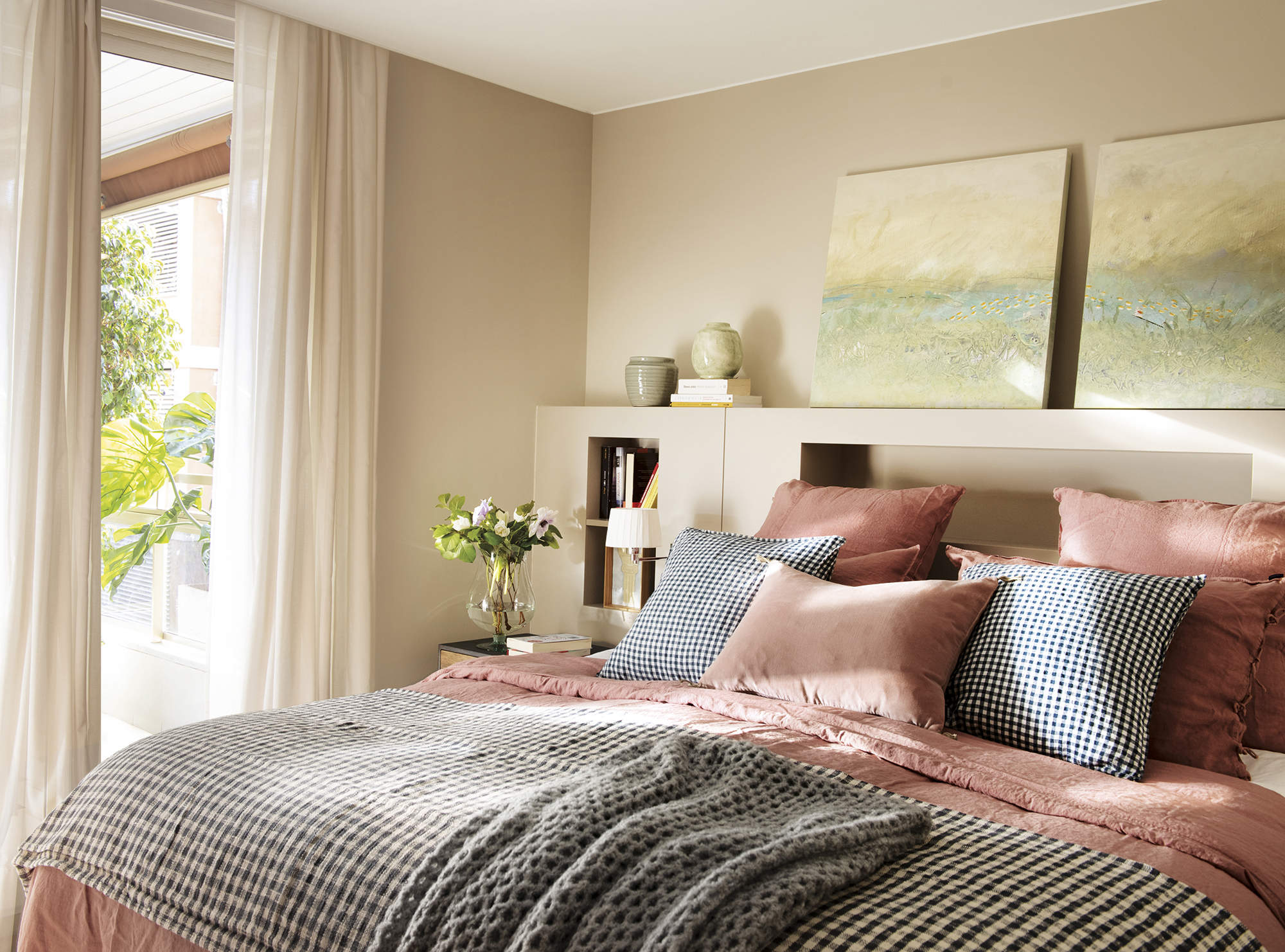 Dormitorio principal con cabecero de obra y ropa de cama rosa y gris