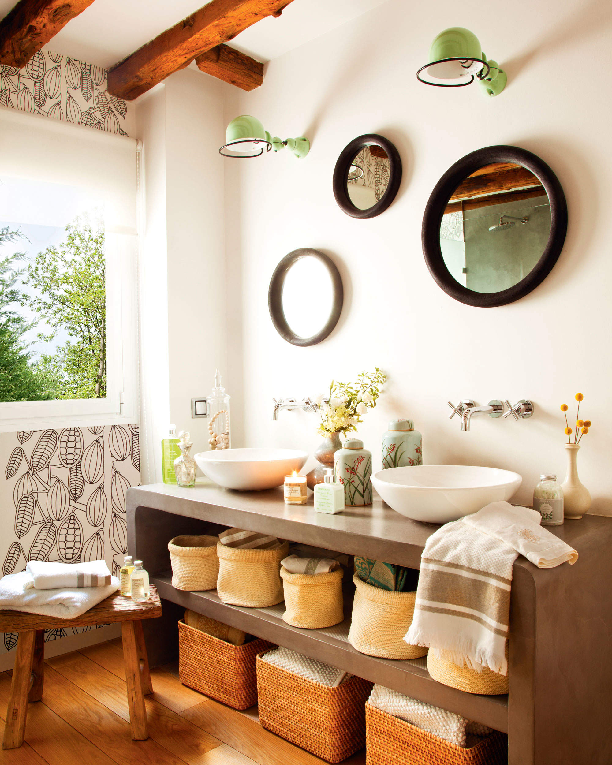 Baño con mueble bajolavabo de microcemento, cestas y espejos encima.