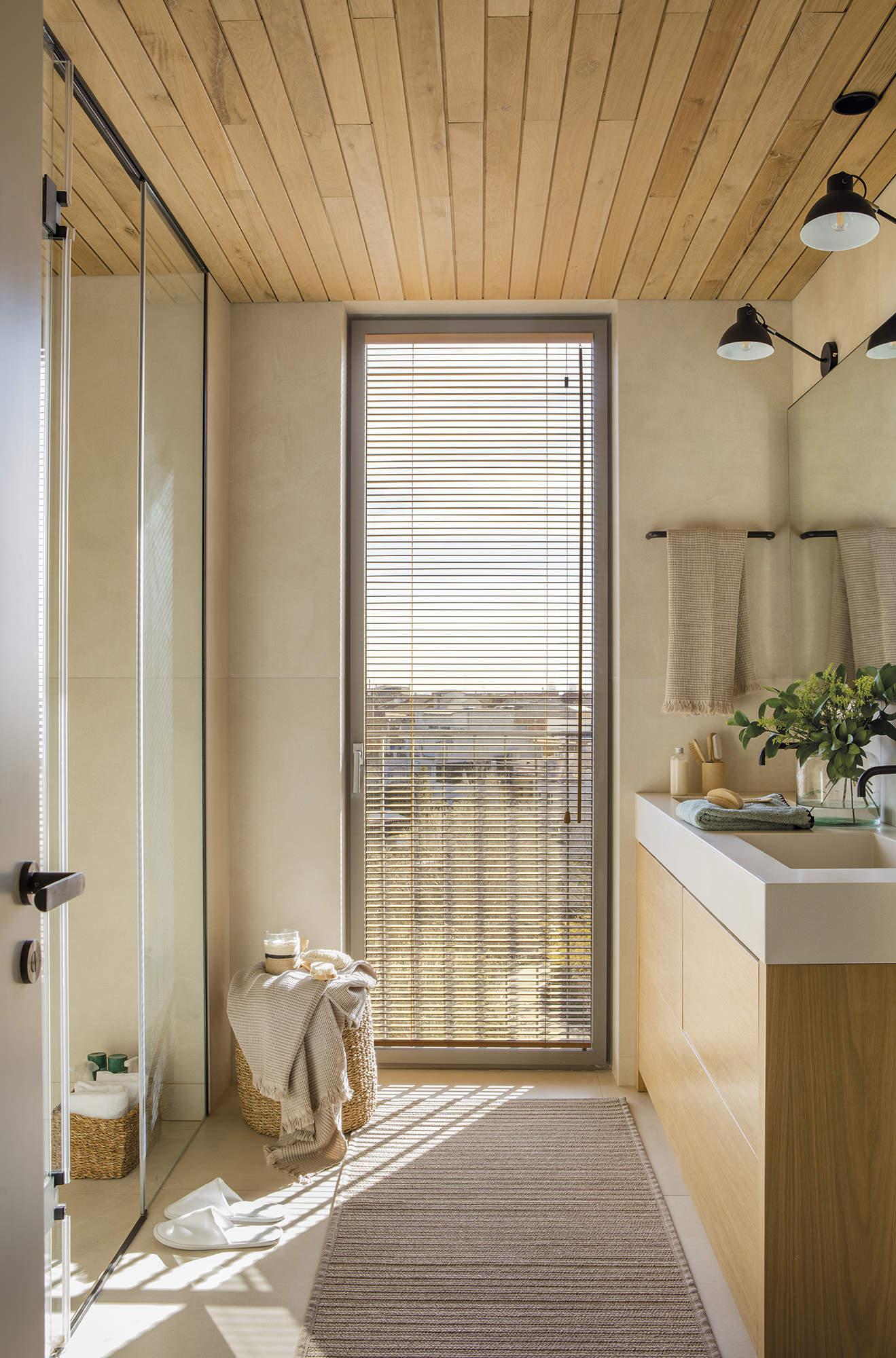 baño con mueble lavamanos de madera y techo de madera.