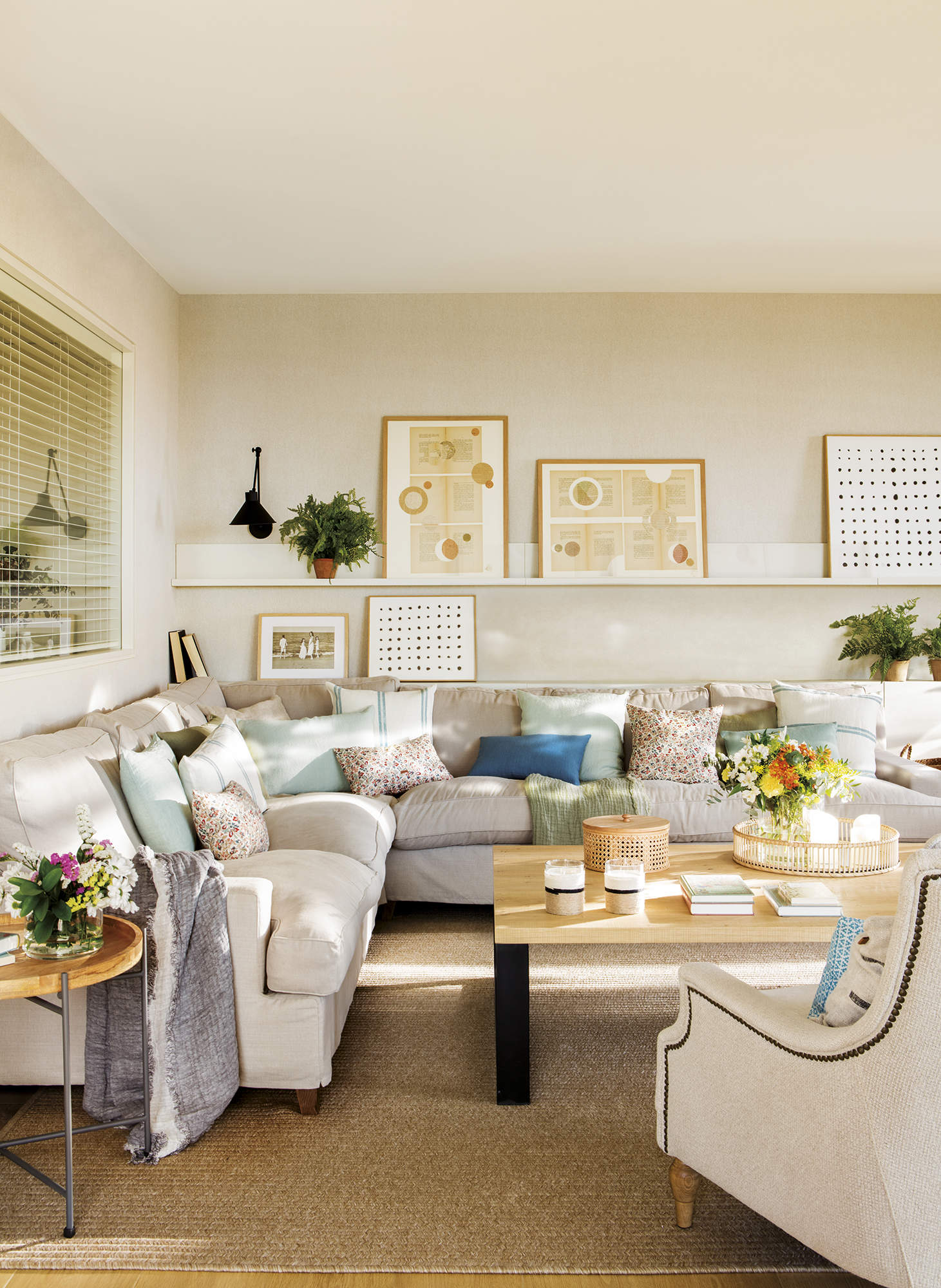 salón pequeño con sofá esquinero gris, cuadros y plantas