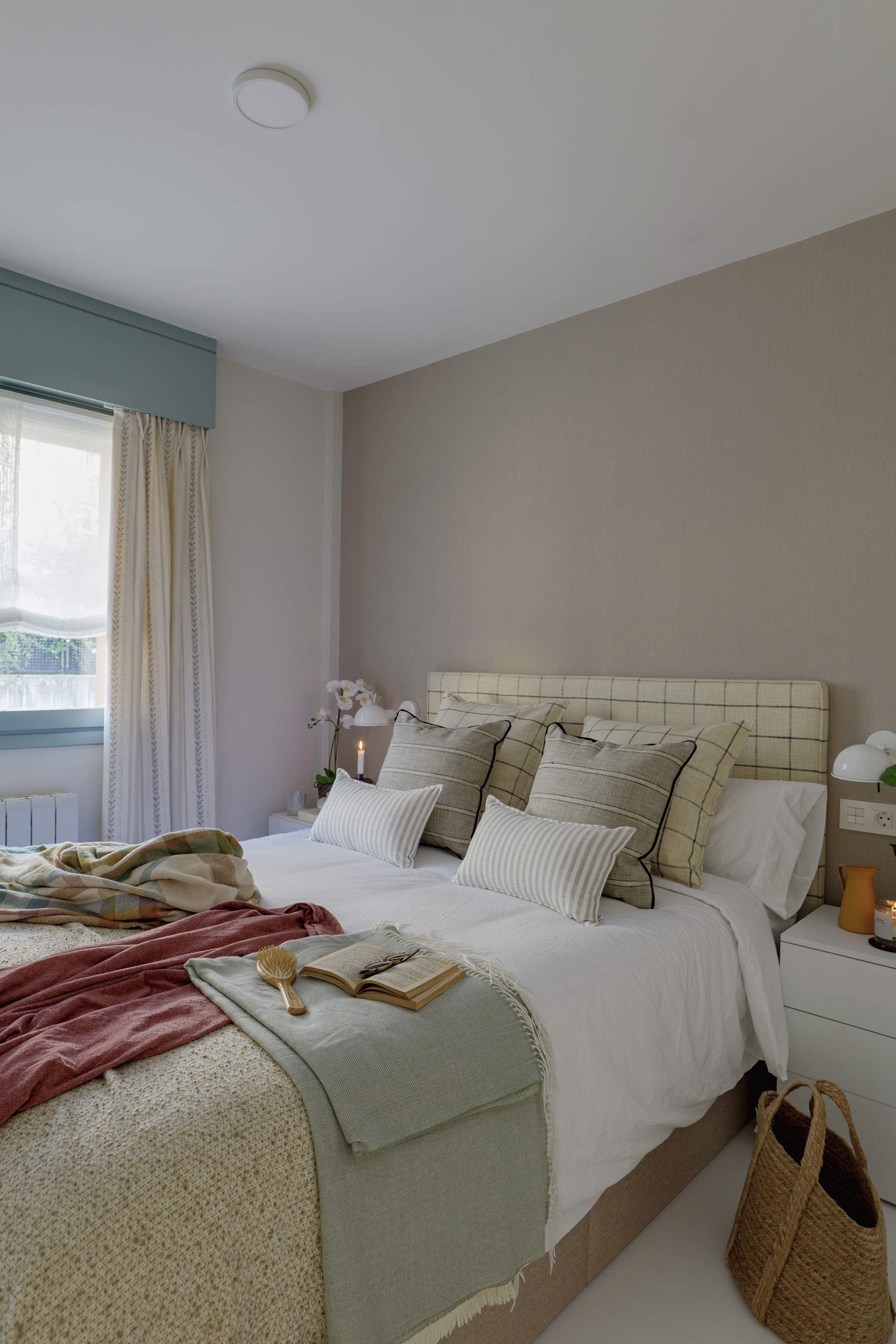 Dormitorio infantil en tonos beige, verde y teja con toques negros en los textiles.