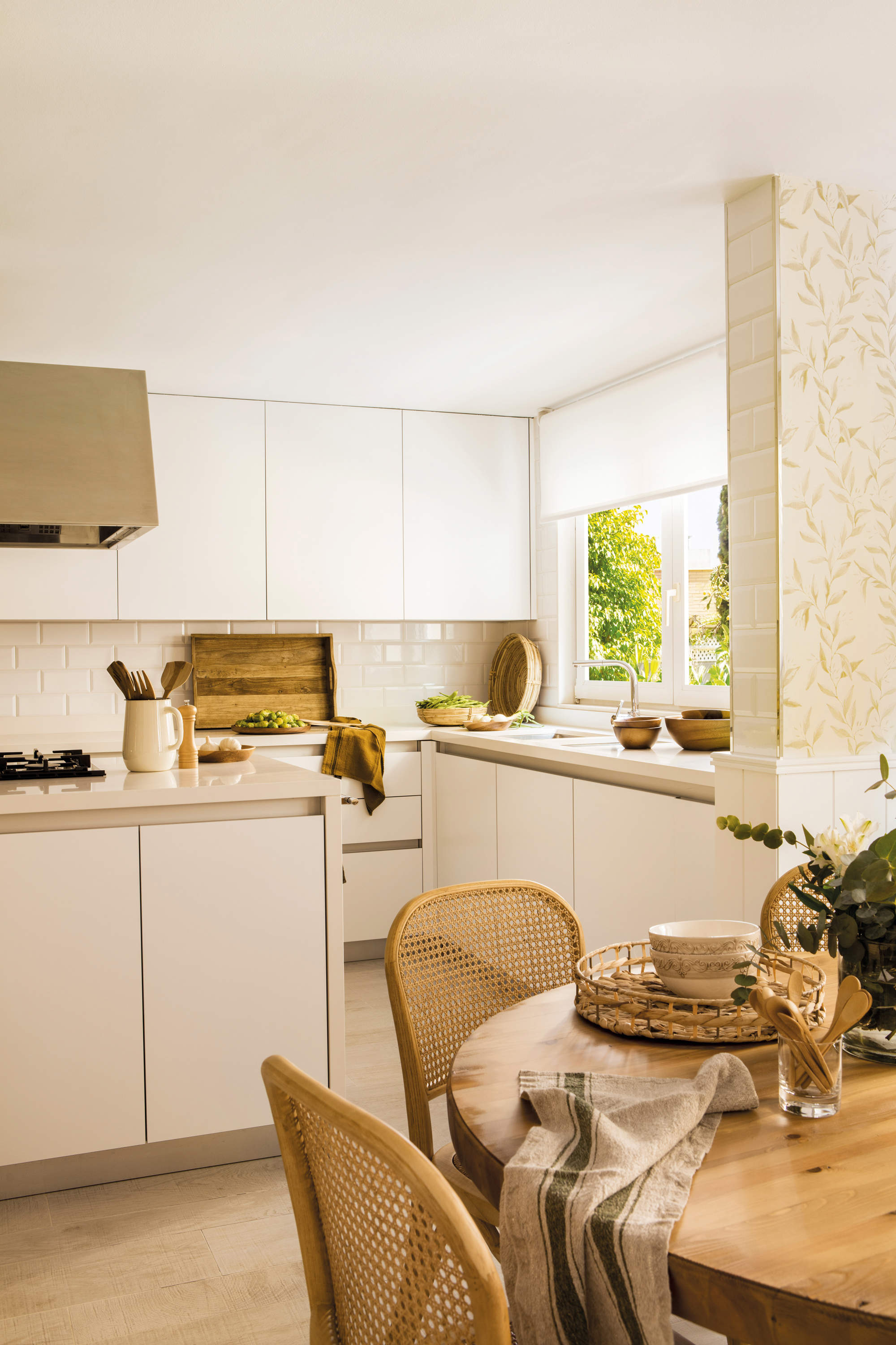 Cocina blanca y moderna con azulejos blancos y pavimento porcelánico que imita madera.