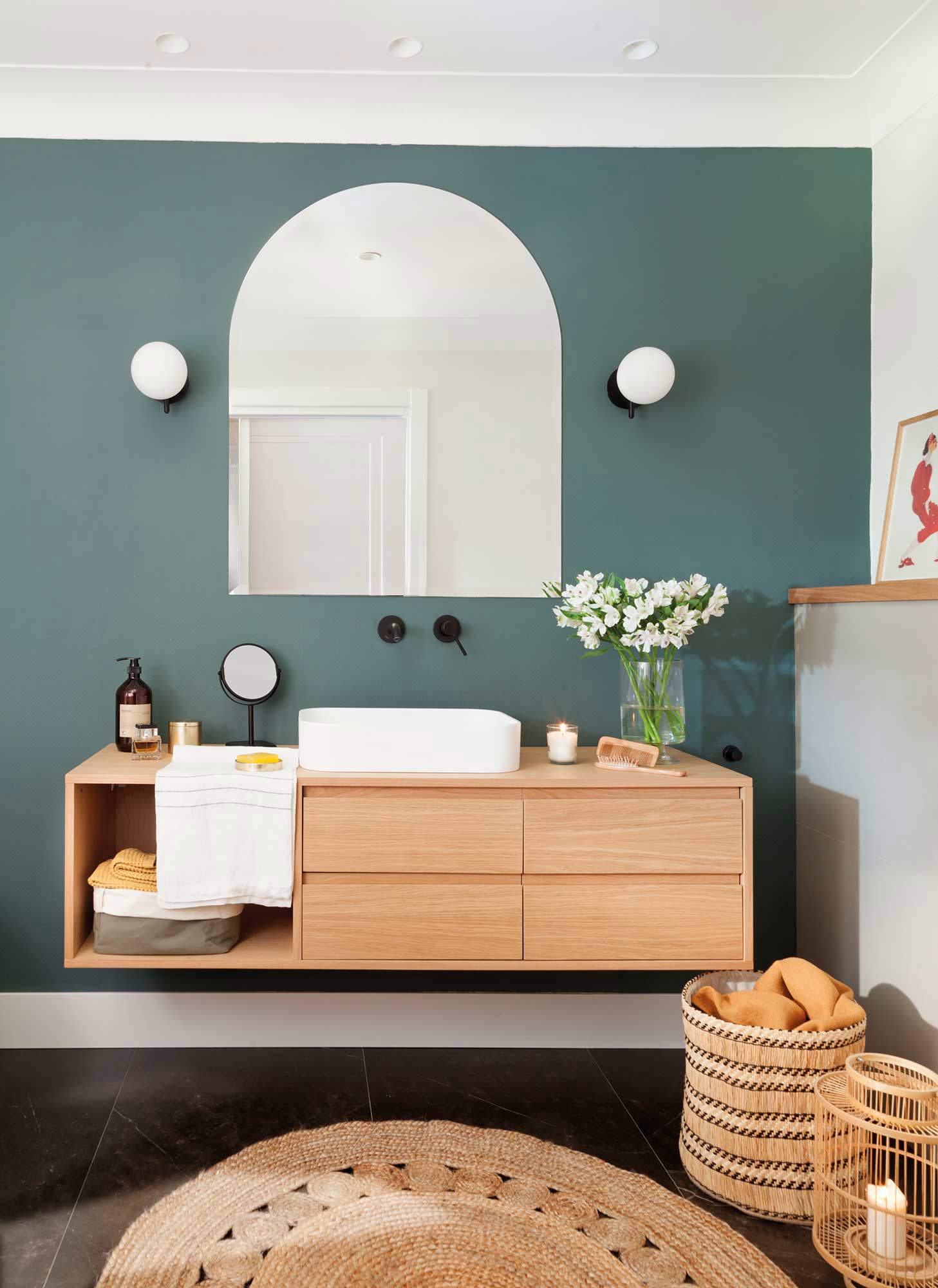 Baño con pared azul, mueble de madera flotante y alfombra de fibras redonda. 