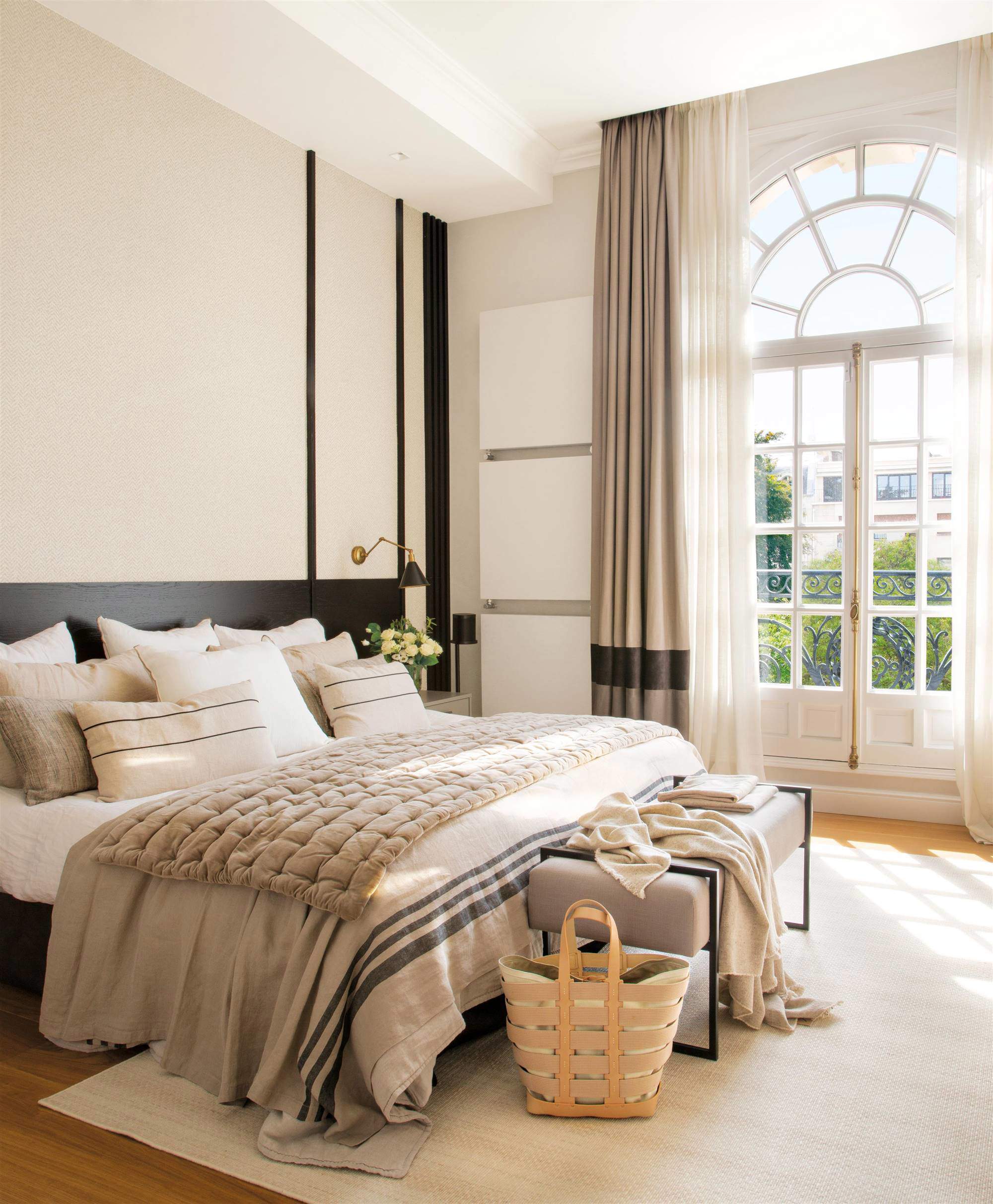 Dormitorio con cabecero de madera lacado en negro y pared empapelada.