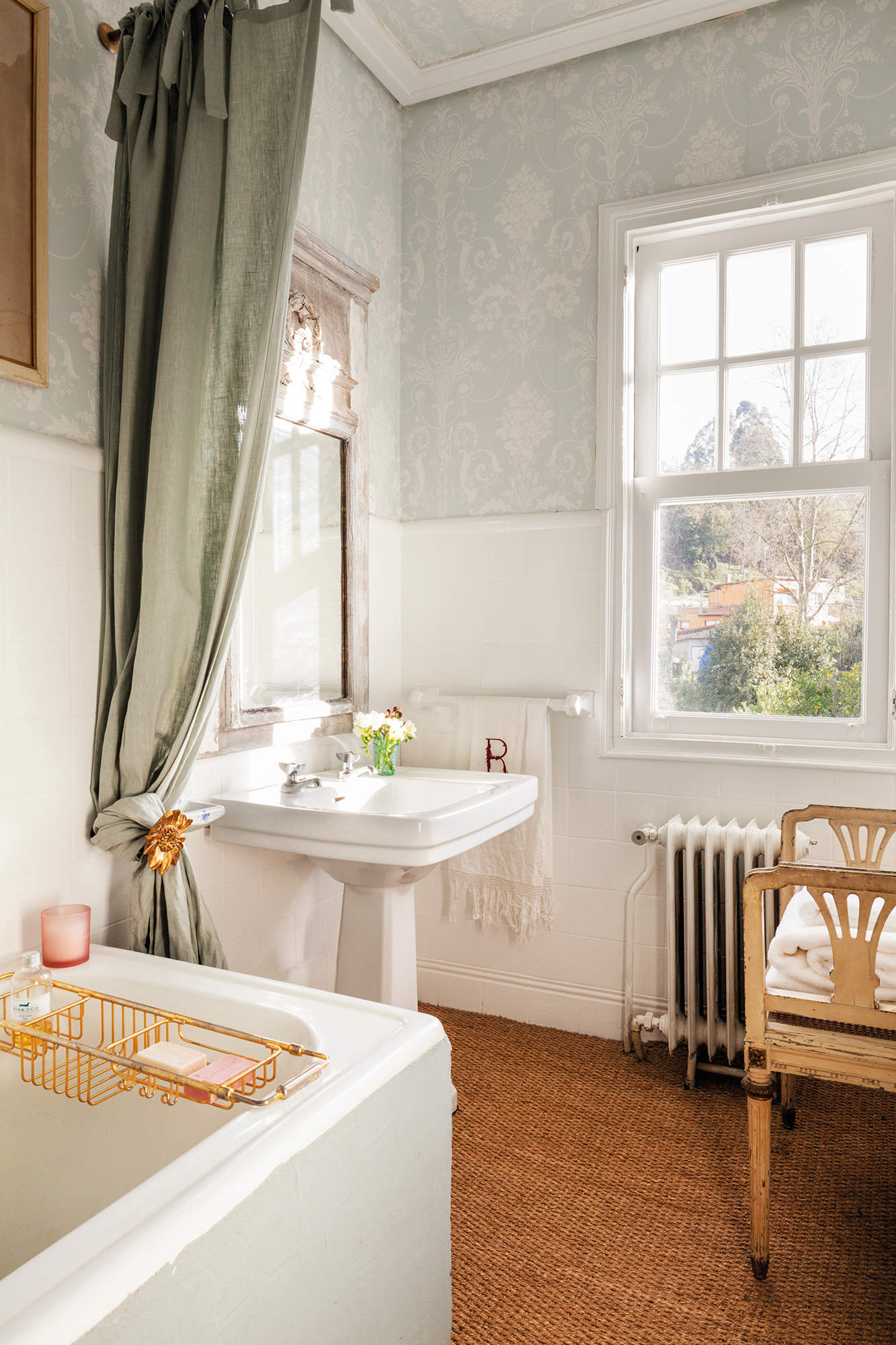 Baño clásico con papel pintado y bañera con cortina. 