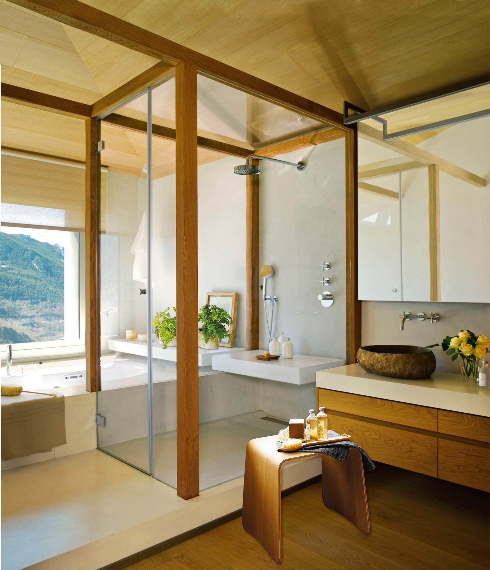 Baño con ducha separada por una pieza escultórica de madera y cristal. 