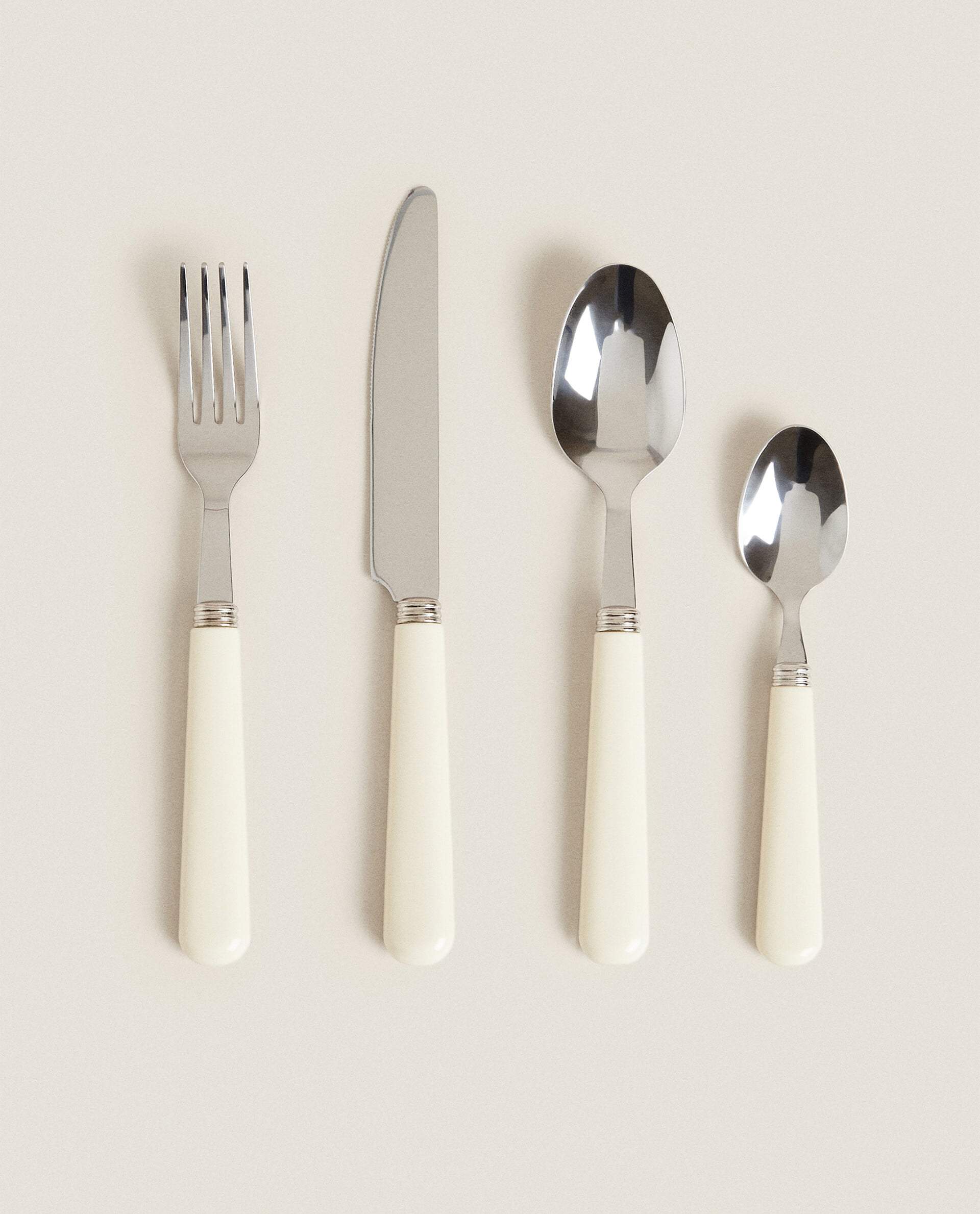 Set de tenedor, cuchillo y cucharas de acero y mango blanco