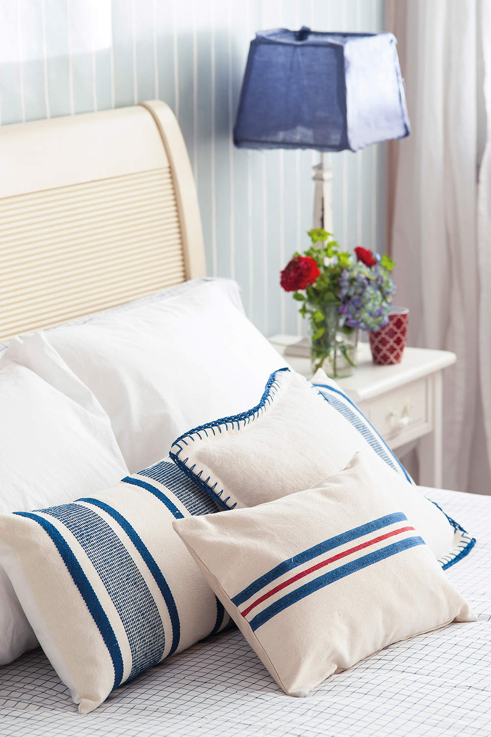 Dormitorio con cojines de rayas estilo marinero. 
