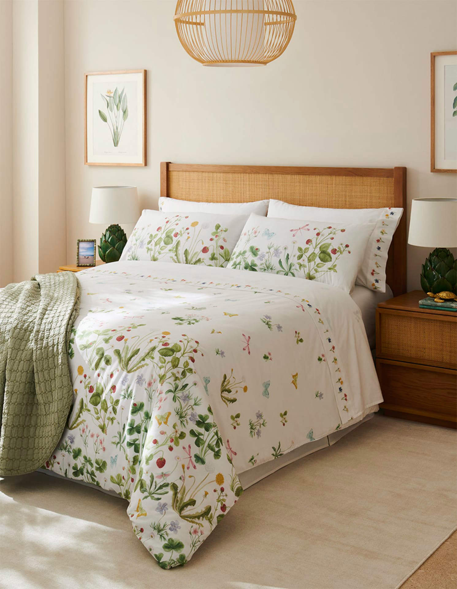 Dormitorio con muebles de madera y ratán y ropa de cama de flores.