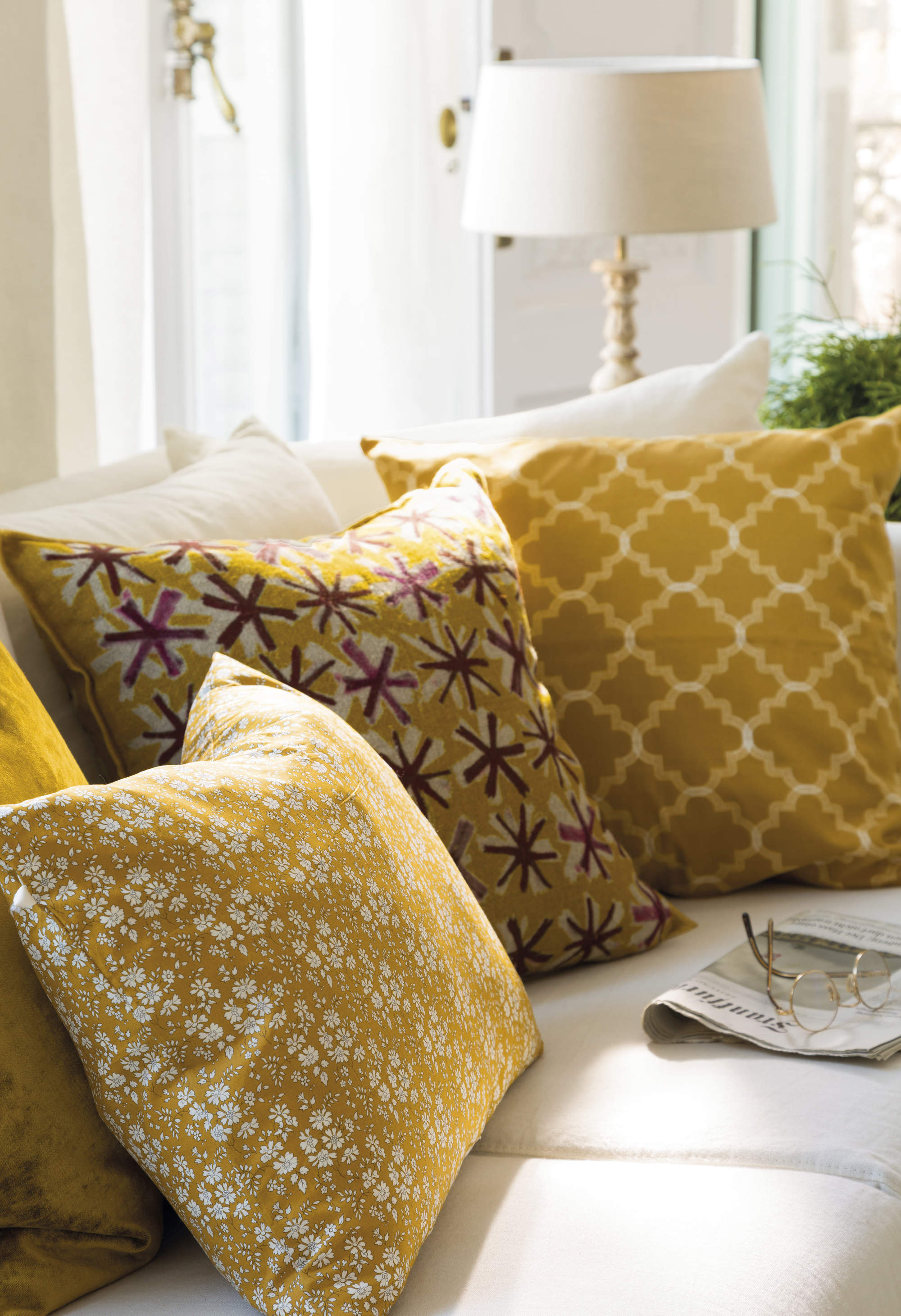 Salón con sofá decorado con cojines amarillos. 
