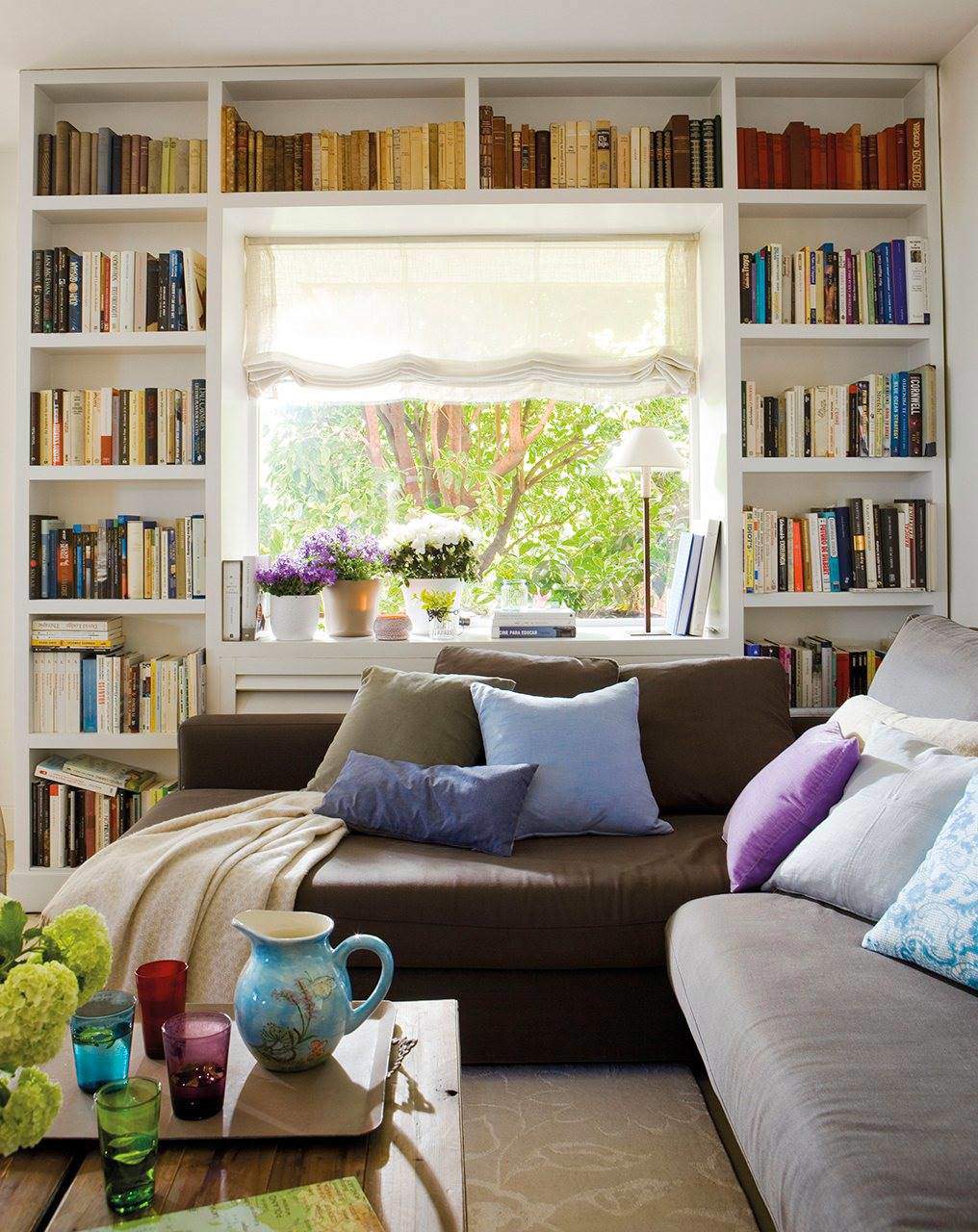 Salón con librería rodeando la ventana. 