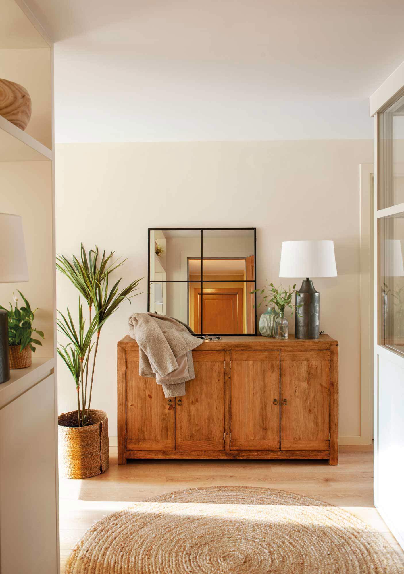 Recibidor con aparador de estilo tradicional de madera, espejo de ventana, y alfombra redonda de ratán.