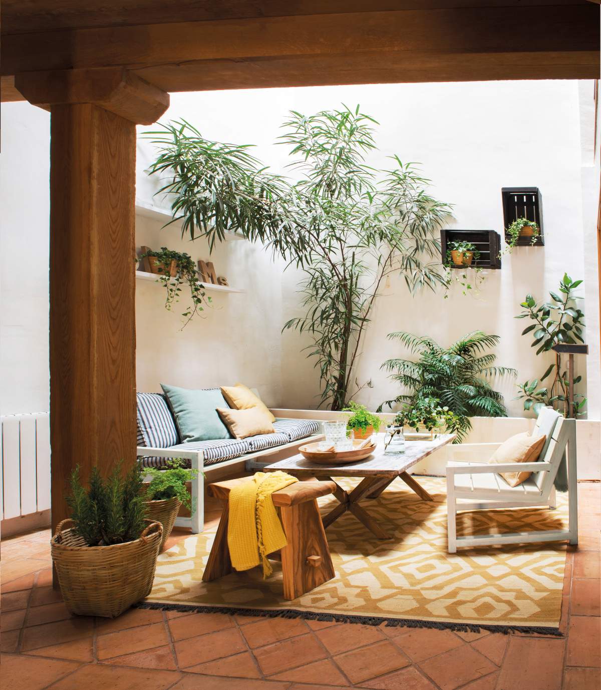 Un patio con plantas de exterior en macetas y sobre estantes.