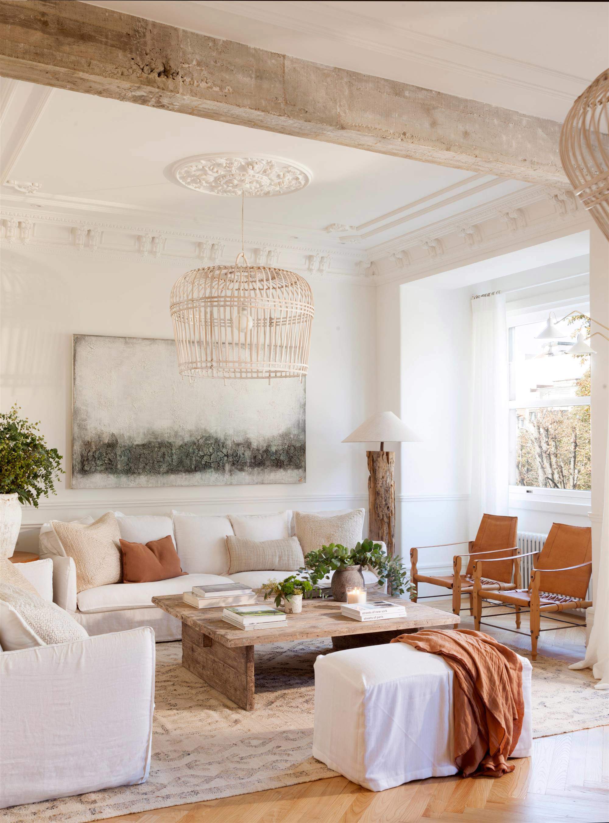 Salón con sofá blanco y elementos arquitectónicos: molduras, vigas.