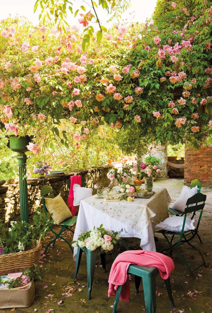 Jardín con pérgola recubierta con rosas.
