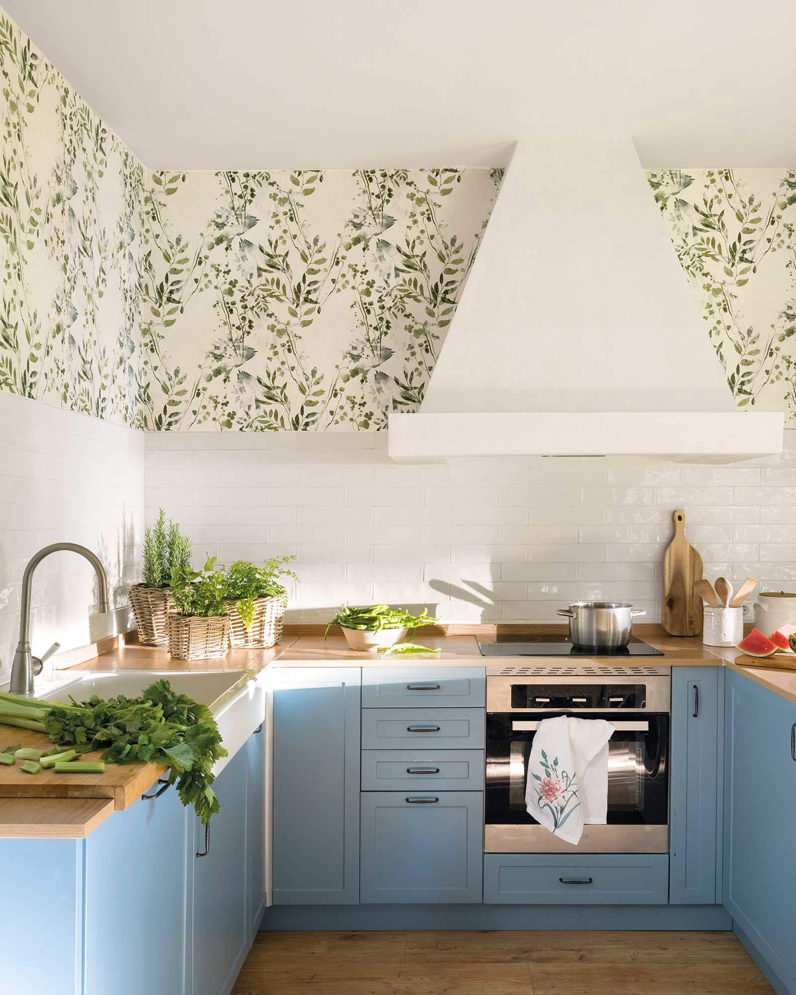 Cocina con paredes con azulejos y papel pintado. 