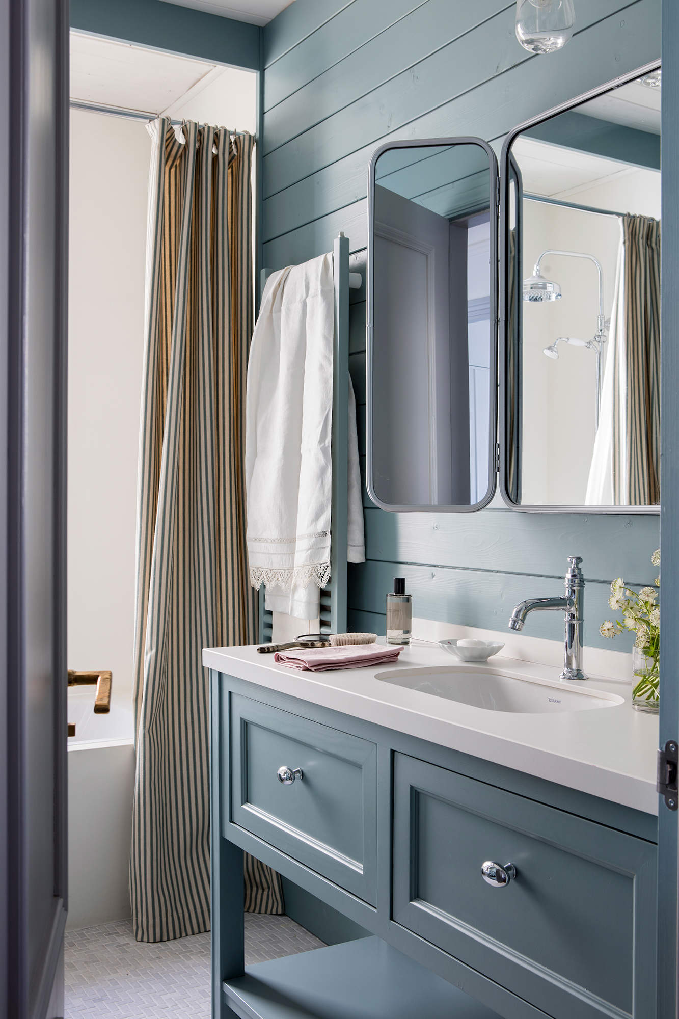 Baño decorado en gris azulado con cortina en la bañera
