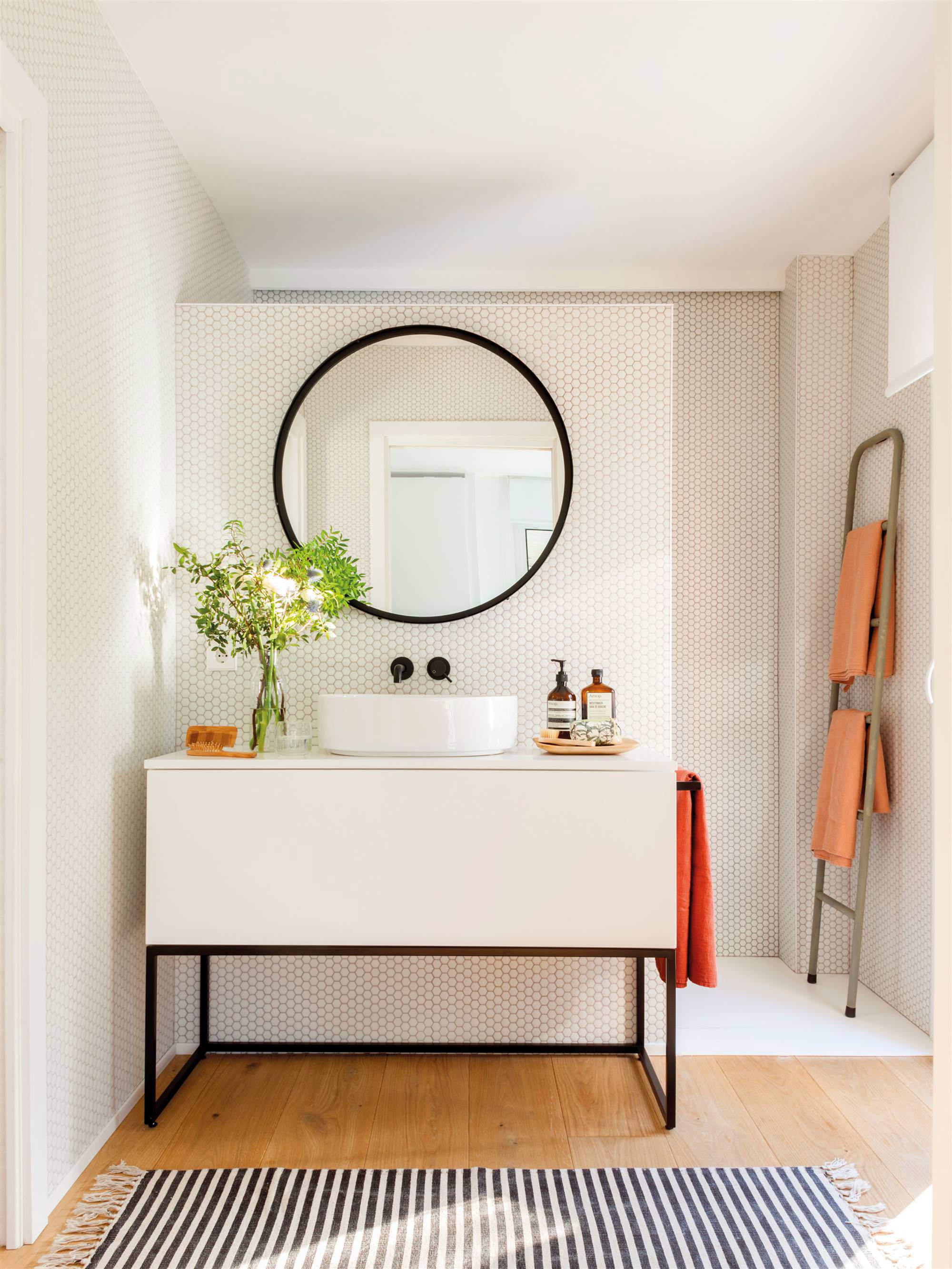 Baño con mueble en blanco y negro y frente de azulejos tipo panal.