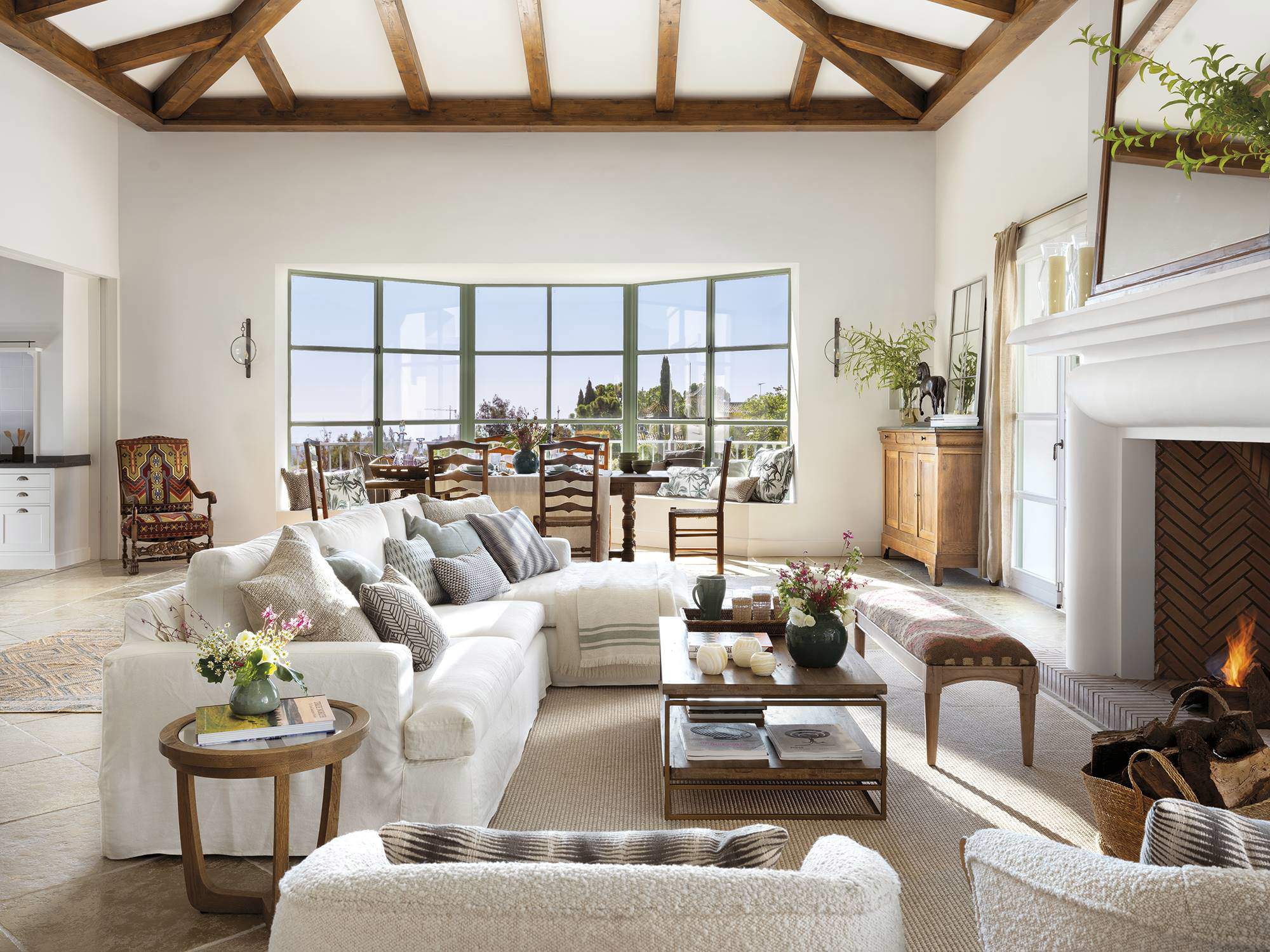 Salón con mobiliario y vigas de madera natural, combinado con blanco y colores naturales.