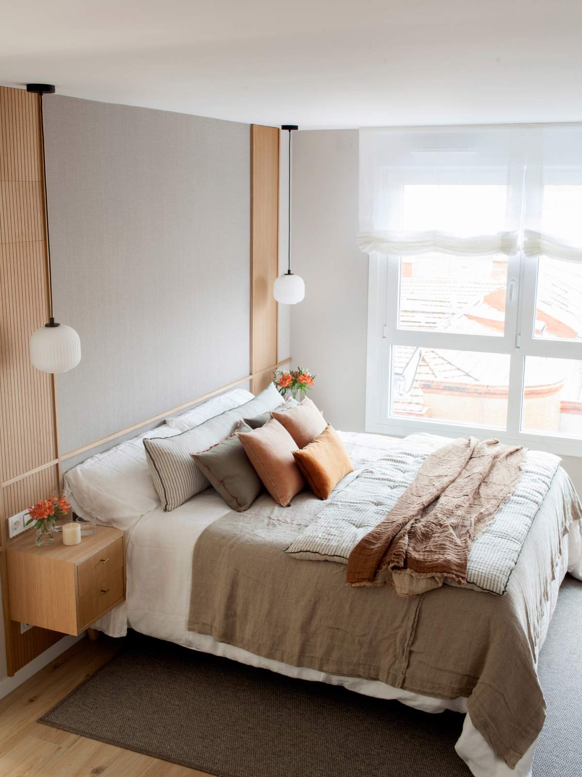 Dormitorio principal en tonos neutros con cojines a color.