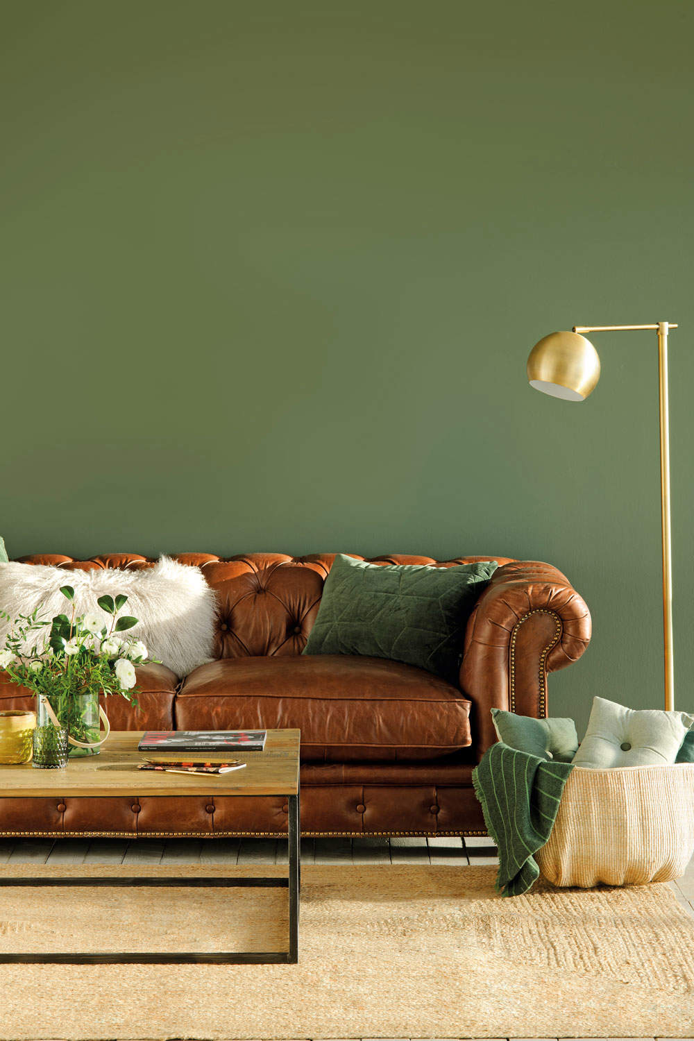 Salón verde con sofá de cuero. 