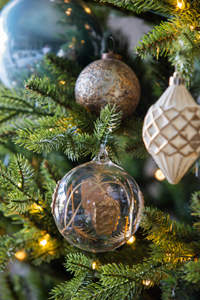 Adornos de cristal y acabados envejecidos para el árbol de Navidad.